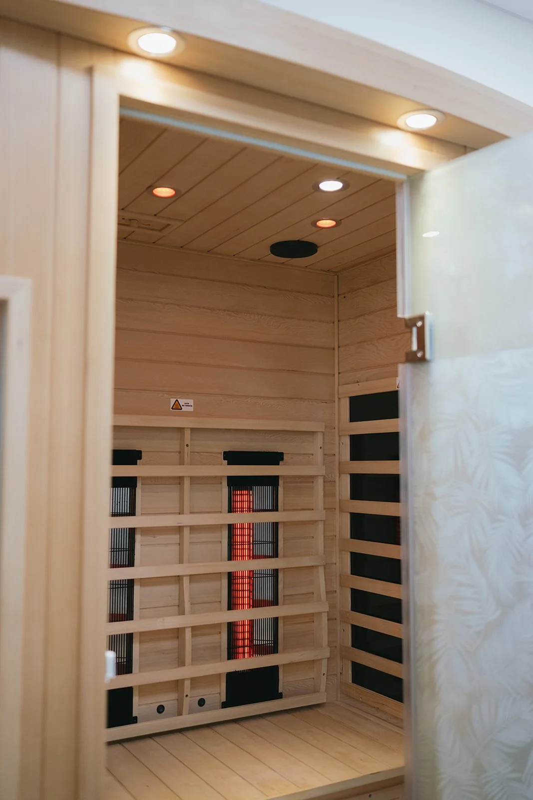 Interior of a wooden sauna with a heater visible in the corner.