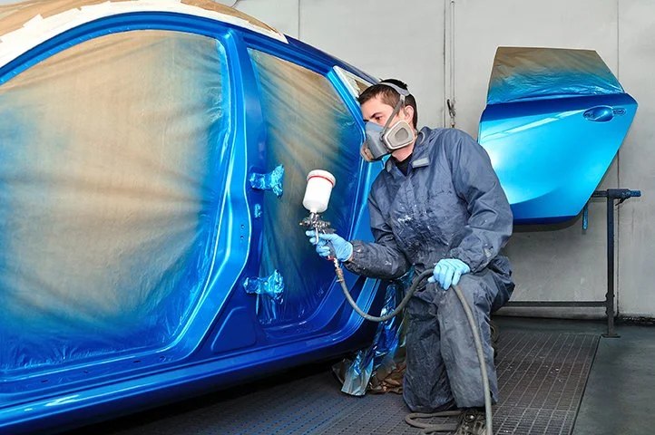 man paints car