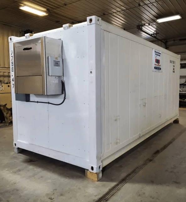 White industrial container with external equipment in warehouse setting.