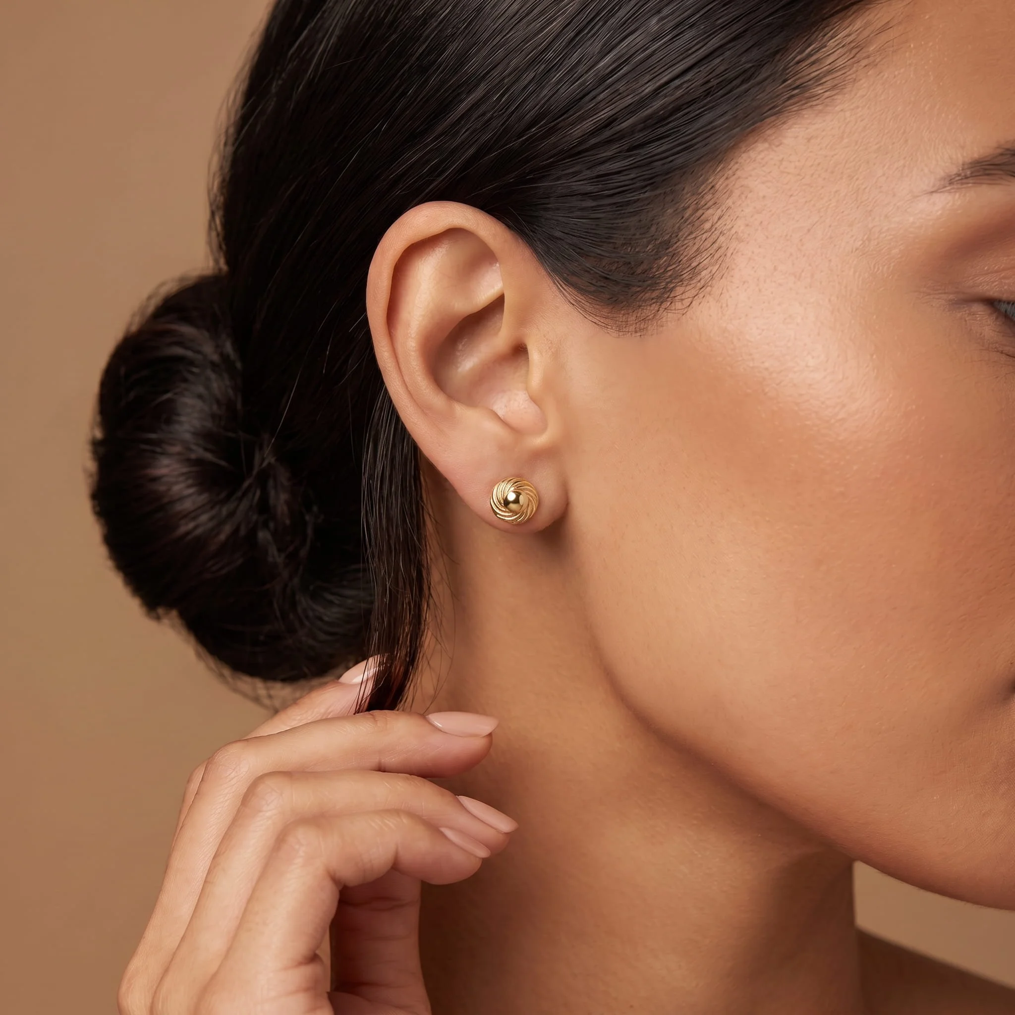 Firefly_Gemini Flash_A close-up profile of a woman's ear wearing a small yellow-gold swirl dome stud earri 808889.jpg