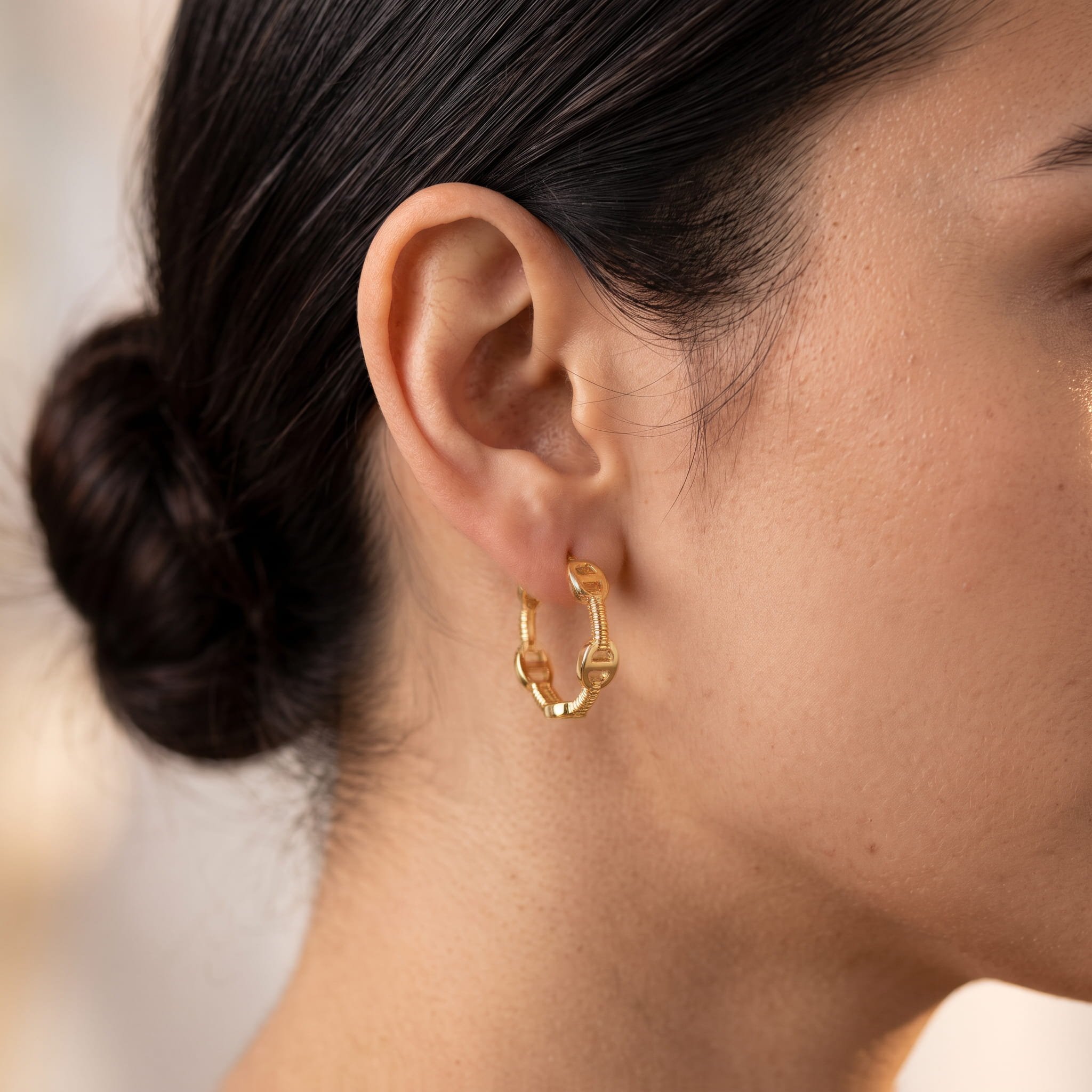 Firefly_Gemini Flash_Close-up profile of a woman's ear wearing an 18K yellow gold hoop earring of restrain 667681.jpg