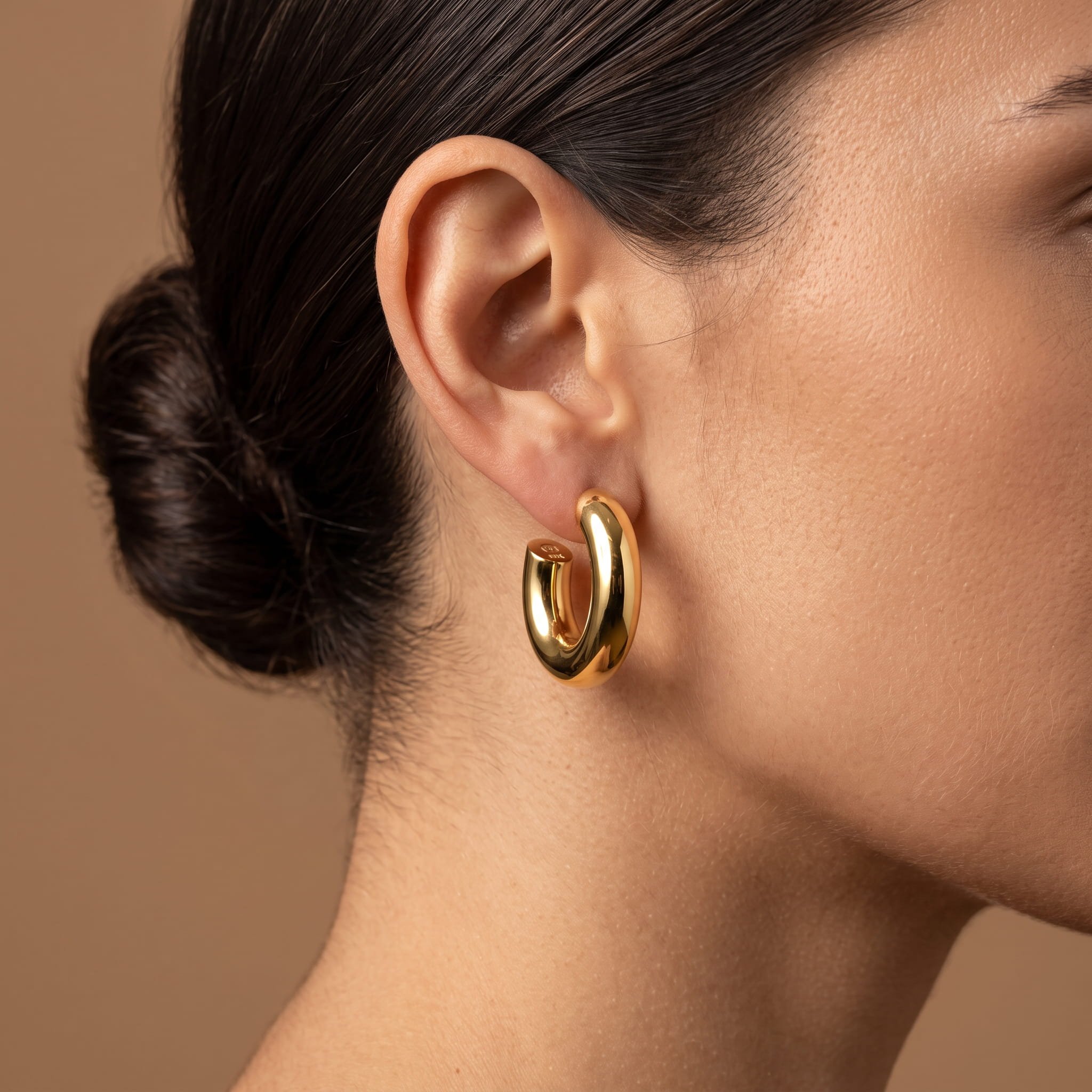 Firefly_Gemini Flash_Close-up profile of a woman's ear wearing a smooth 18K yellow gold tube hoop earring  667681.jpg