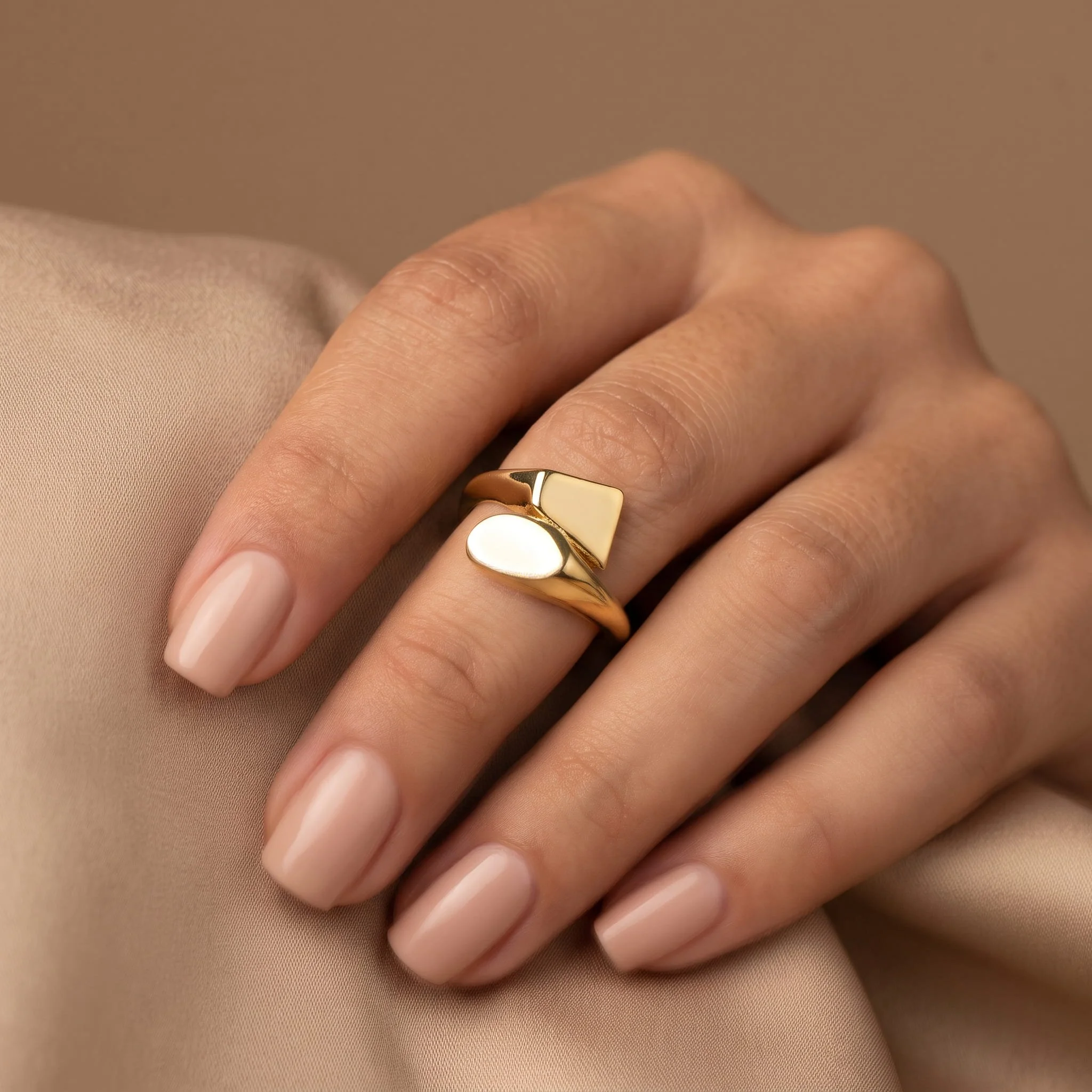 Firefly_Gemini Flash_Close-up of a woman's hand wearing an 18K yellow gold sculptural bypass ring of refin 666066.jpg (Copy)