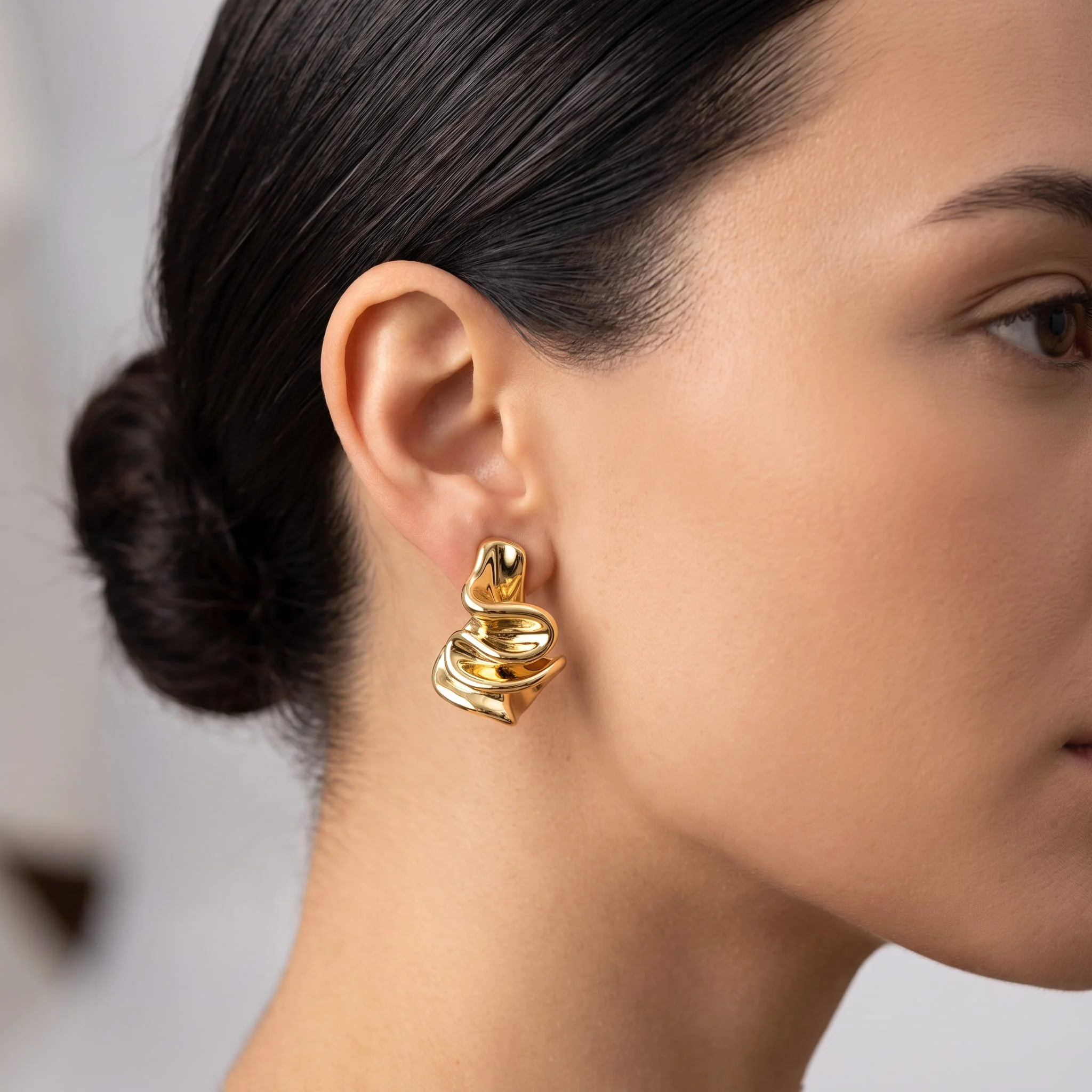 Firefly_Gemini Flash_Close-up profile of a woman's ear wearing a sculptural 18K yellow gold drop earring o 667681.jpg