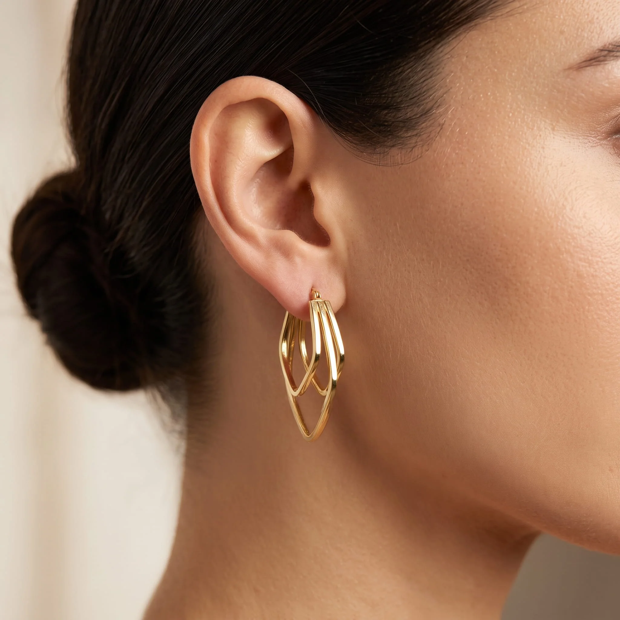 Firefly_Gemini Flash_Close-up profile of a woman's ear wearing an 18K yellow gold triple layered hoop earr 666066.jpg