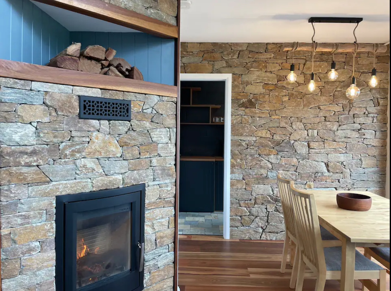 Renovated living and dining area with stone fireplace in the Southern Highlands