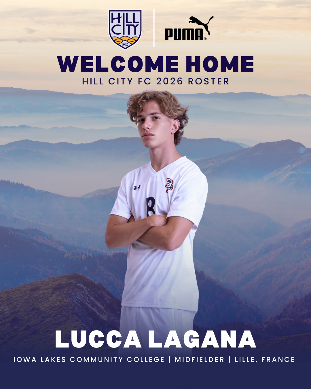A young man in a white soccer uniform with the number 8 stands with crossed arms in front of a mountain landscape at sunrise or sunset. The image promotes Hill City FC's 2026 roster, with logos of Hill City FC and Puma at the top. Text indicates the player is Lucca Lagana, a midfielder from Iowa Lakes Community College, based in Lille, France.