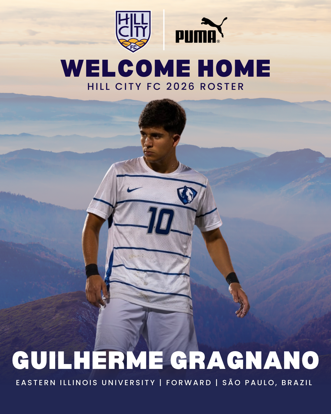 A soccer player in a white and blue uniform with the number 10, standing in front of a mountainous landscape, welcoming home for Hill City FC 2026, in partnership with Puma, revealing Guilherme Gragnano from Eastern Illinois University, a forward from São Paulo, Brazil.
