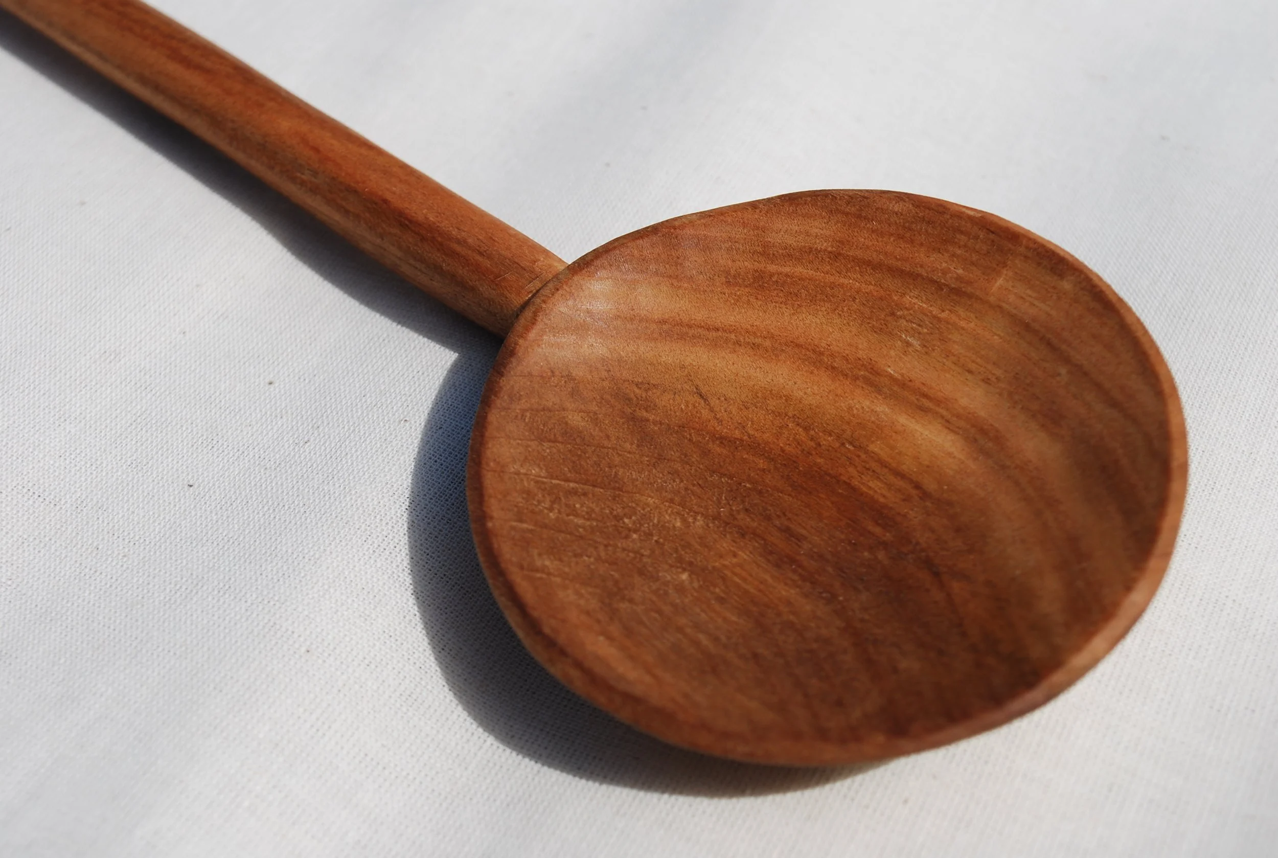 Close-up of a wooden spoon on a white surface.