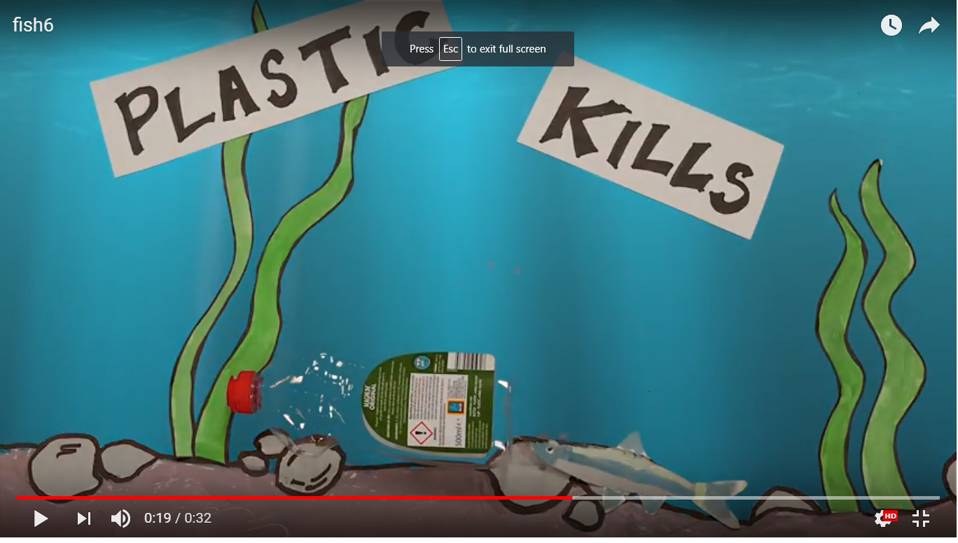 A colorful underwater-themed display with the words 'Plastic Kills' on cut-out signs, featuring illustrations of seaweed, rocks, a water bottle, and a fish.