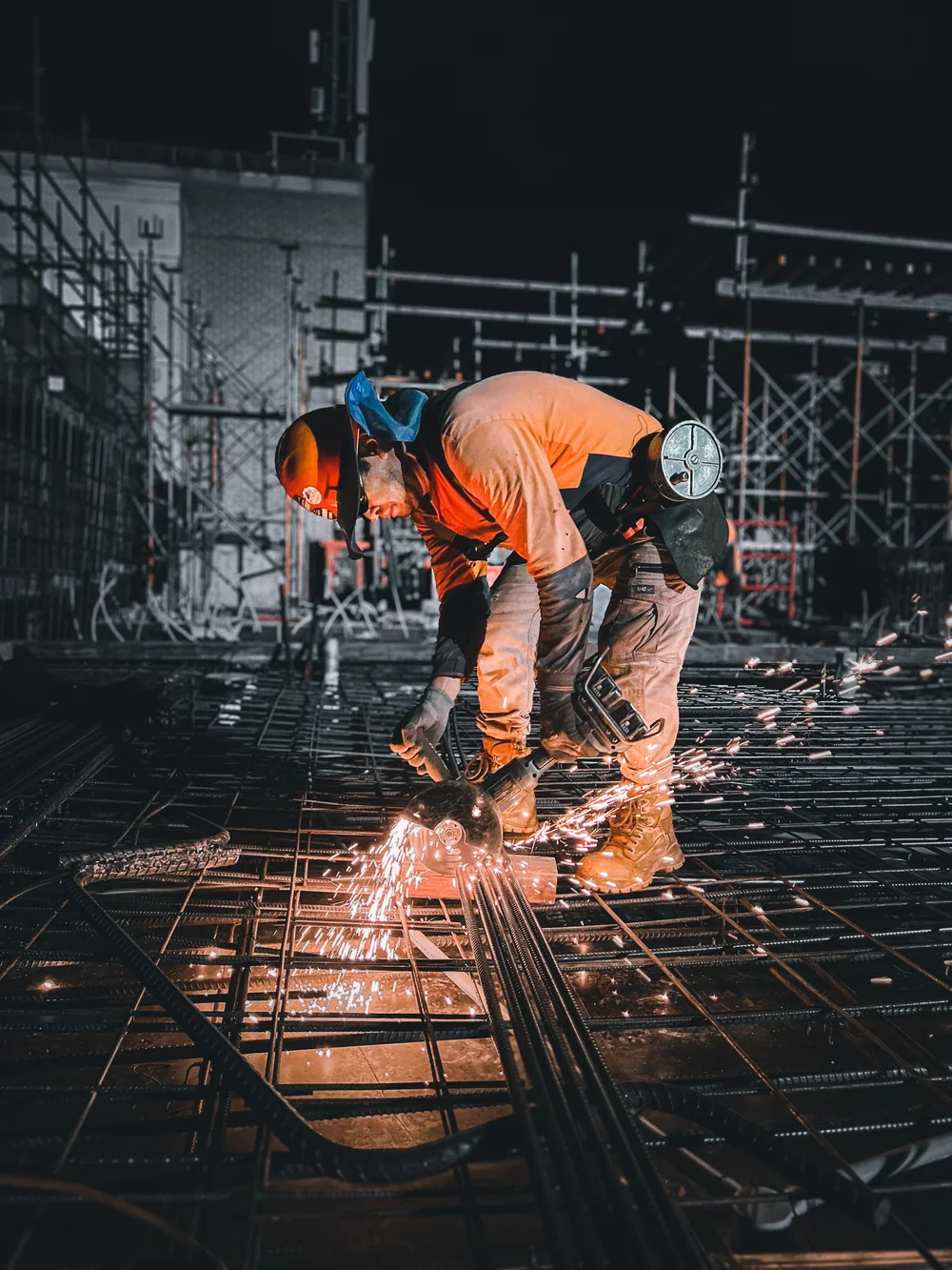 MJK crew cutting reinforcement bar on site, sparks flying