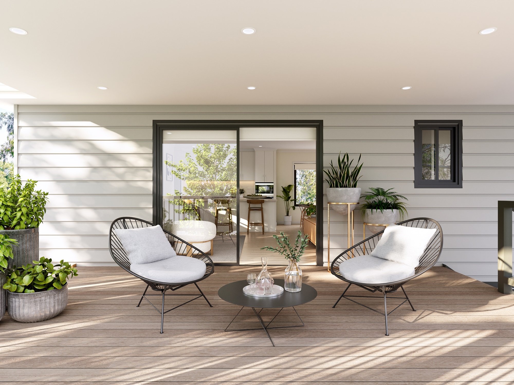 Stylish modern patio with two lounge chairs, a small round table, potted plants, wooden decking, sliding glass door opening to a bright living space.