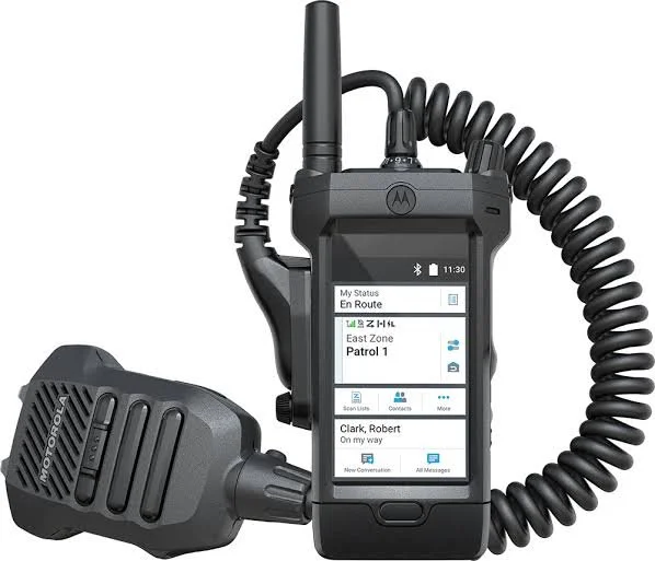 A Motorola two-way radio with a large touchscreen display, multiple buttons, and a coiled microphone attached.