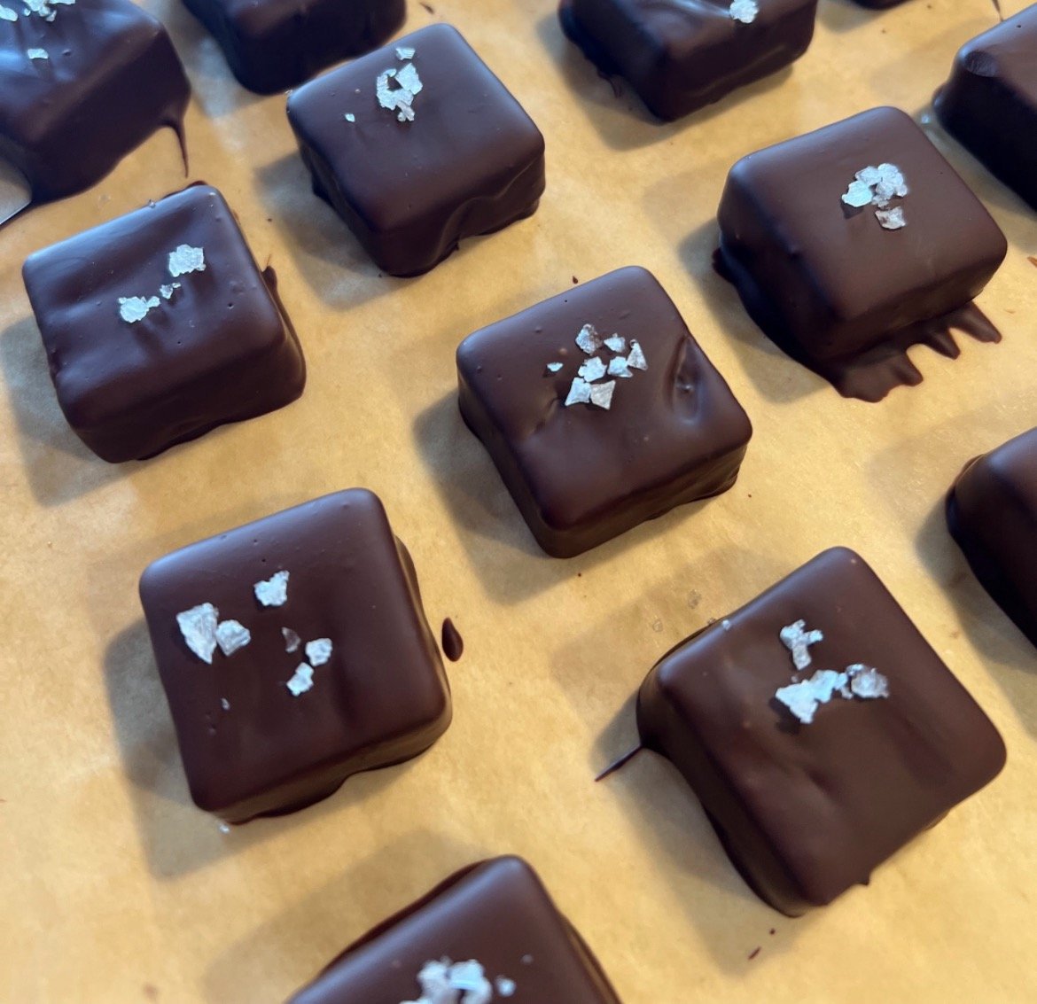 Handmade vegan sea salt caramels dipped in dark chocolate, topped with sea salt, crafted on a family homestead
