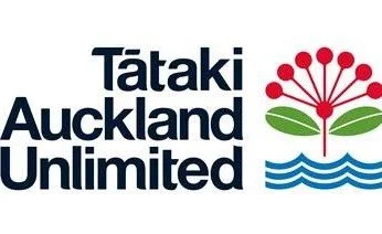 Logo for Tātaki Auckland Unlimited featuring a stylized red flower with green leaves and blue waves.