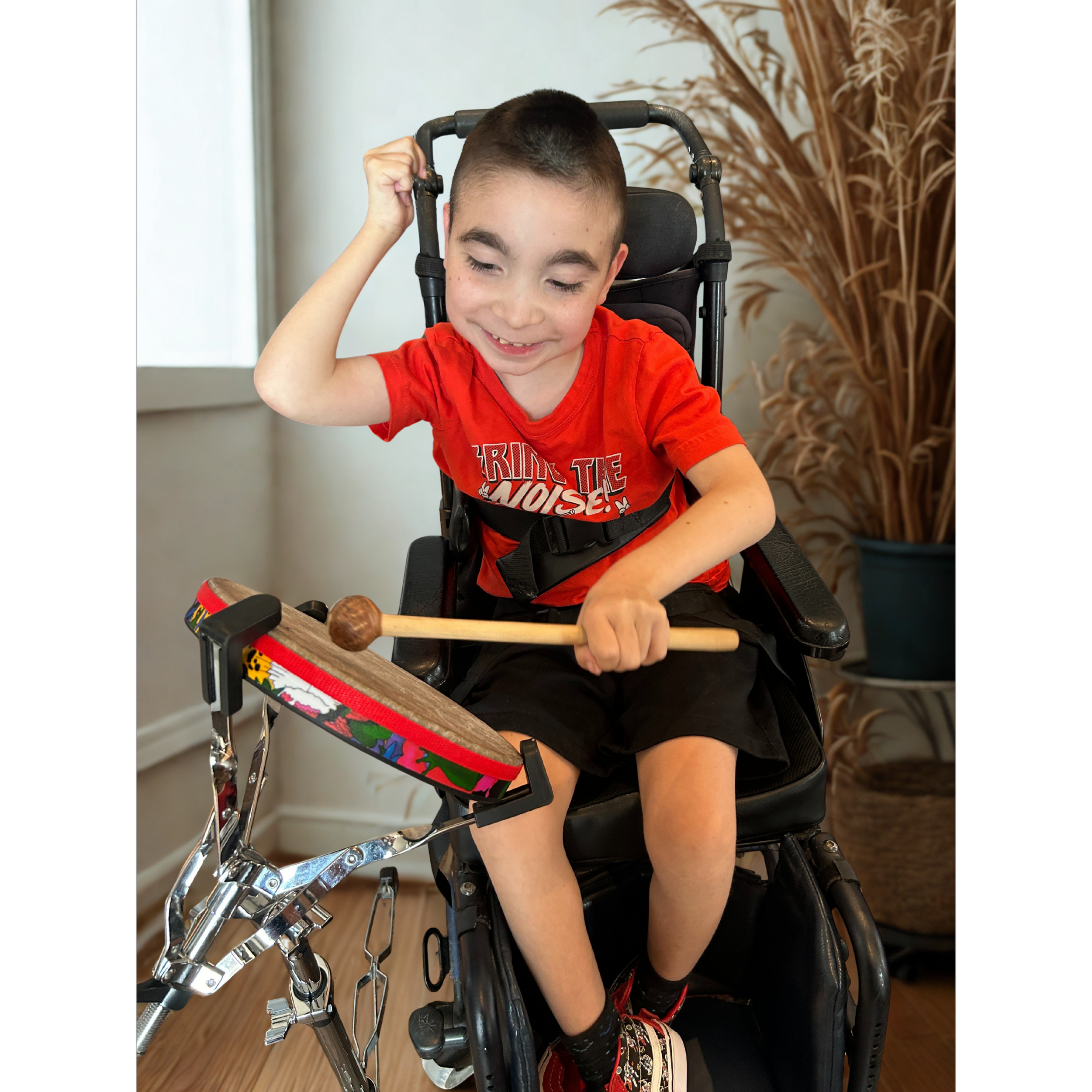 boy in a wheelchair playing a drum
