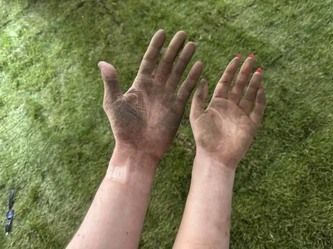 deux dirty hands in front of a grass floor