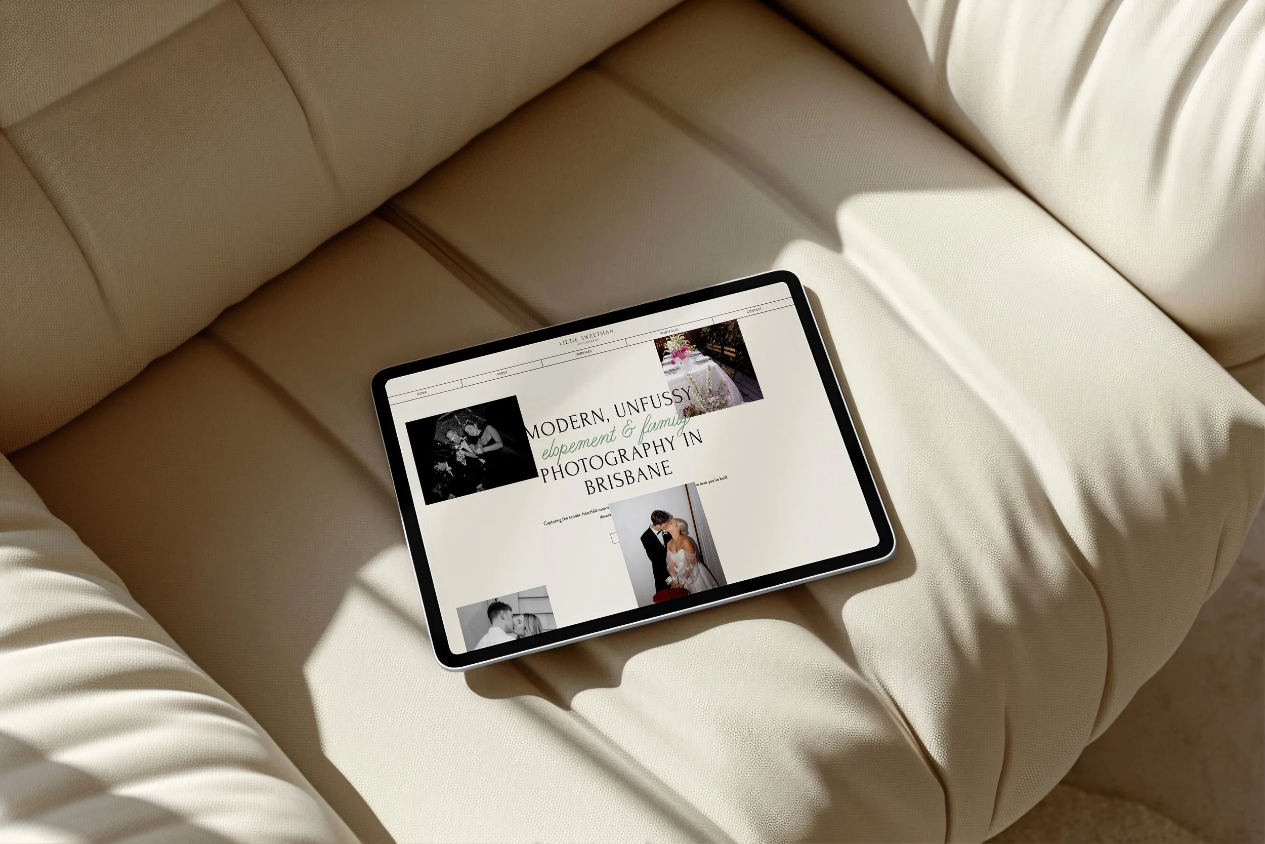 Person sitting cross-legged on a black textured rug, using a silver laptop and holding an open planner with a black pen.