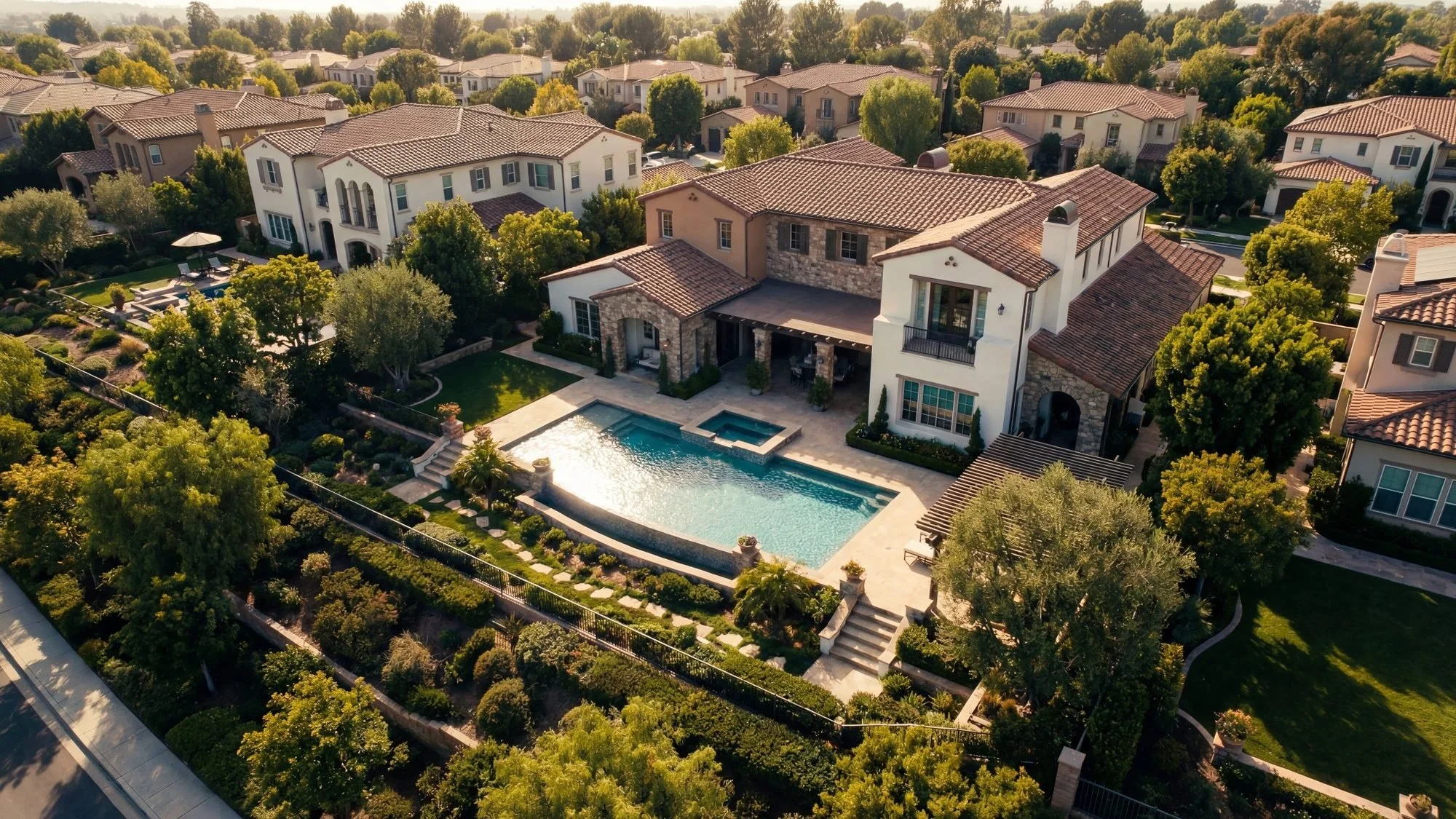 Aerial drone photo of a luxury suburban home and backyard pool for a real estate listing.