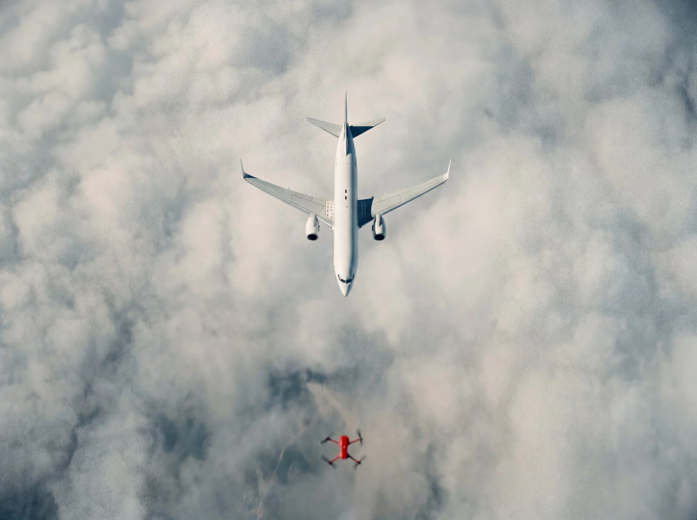 Aerial view of a commercial passenger jet flying above clouds with a small red drone below it, illustrating a potential drone encounter near controlled airspace.