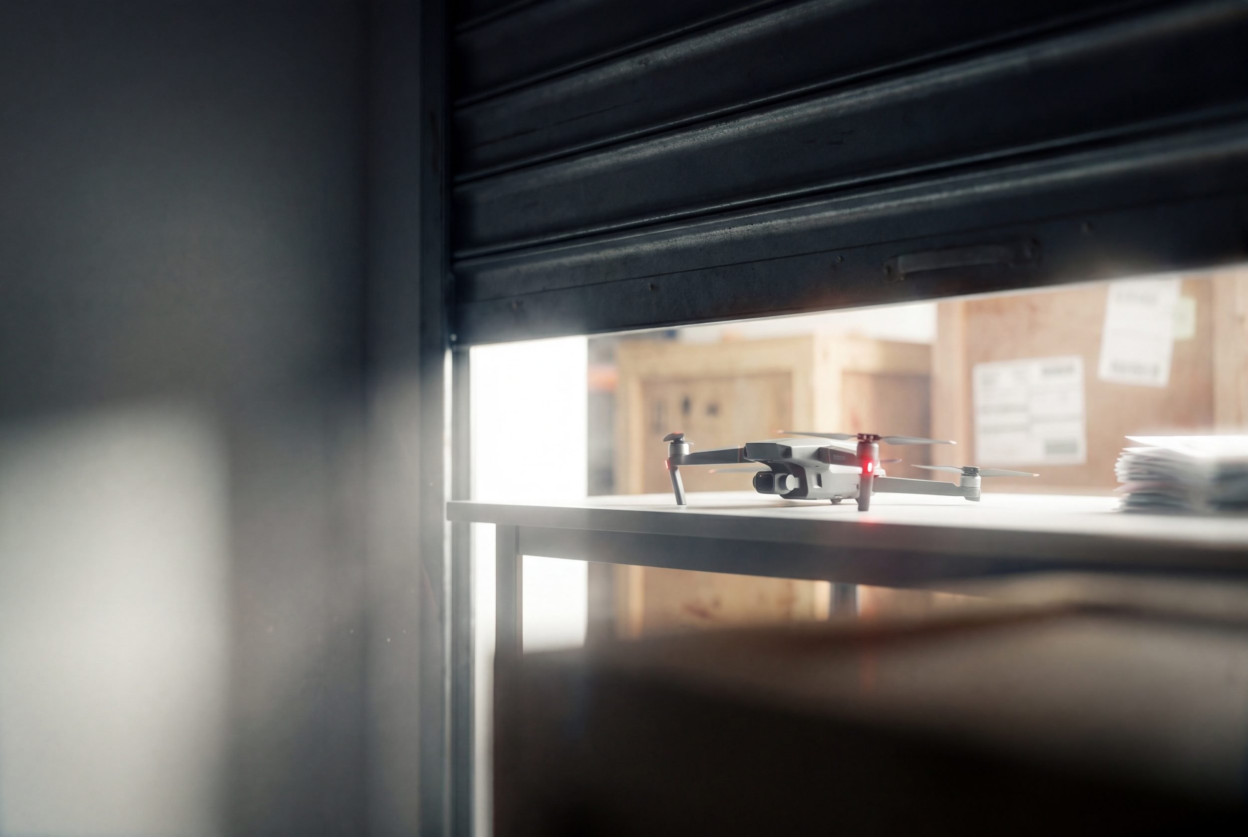 Drone shipment boxes and equipment staged near a warehouse loading dock, representing new drone products blocked from entering the U.S. market.