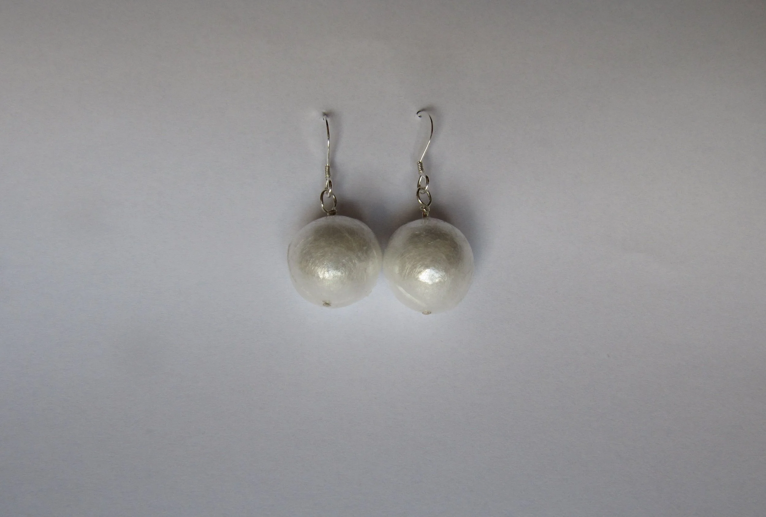 Cling film, many layers of cellophane and silver pendant