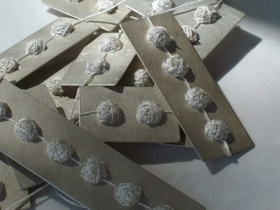 Plaquettes, silver and silk thread