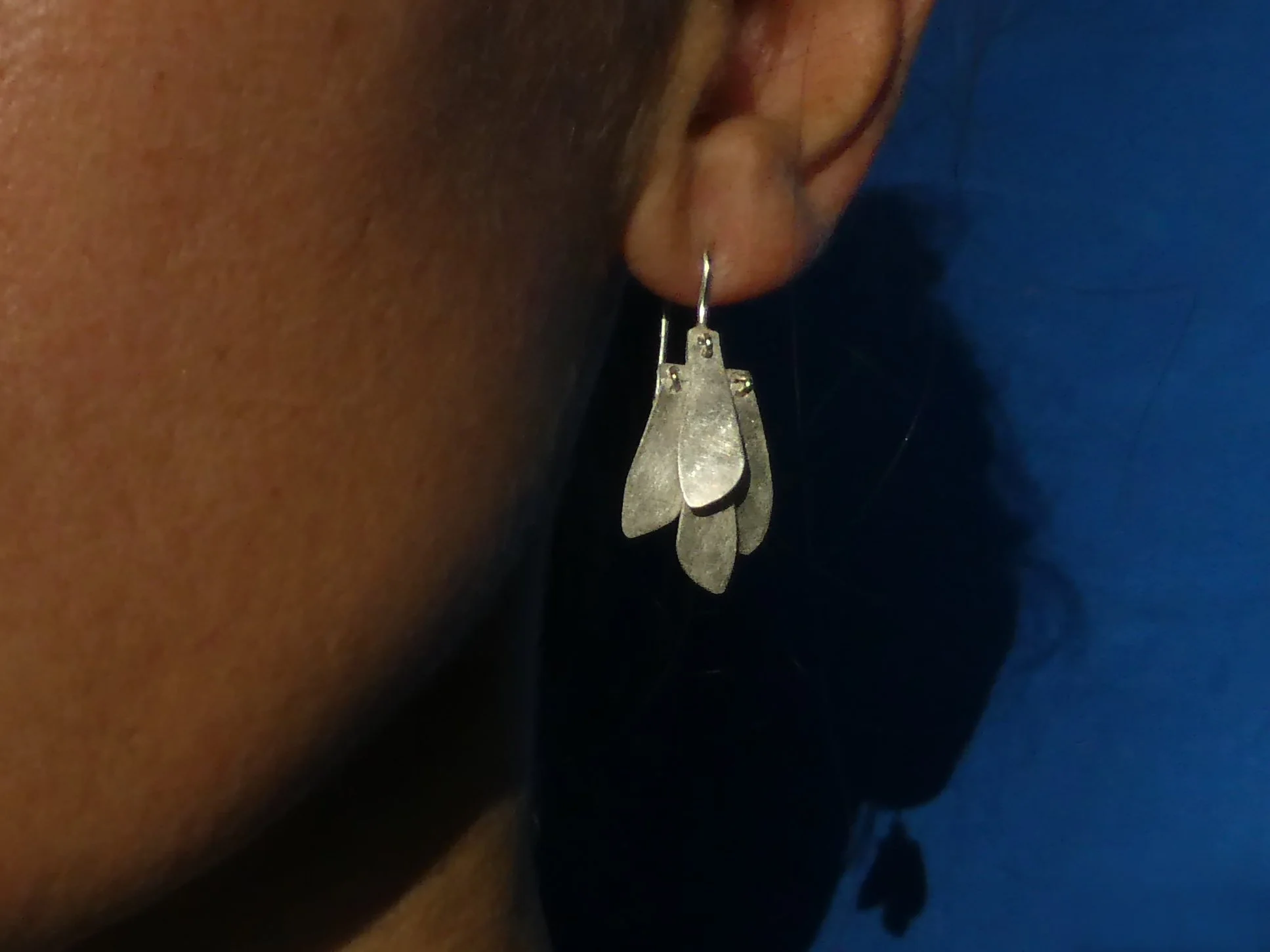 Whisper – earrings in silver: Dangling silver earrings handmade in Switzerland, contemporary jewelry with moving elements reflecting light and sound
