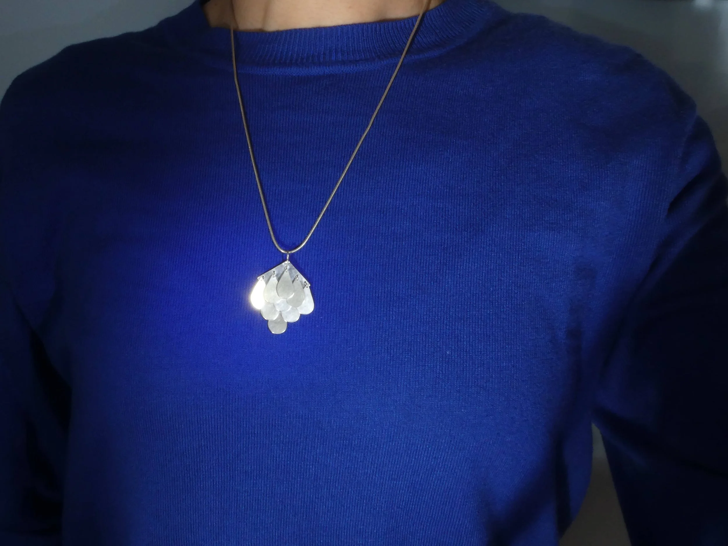 Contemporary silver pendant with moving drops, handmade jewelry Switzerland reflecting light and motion