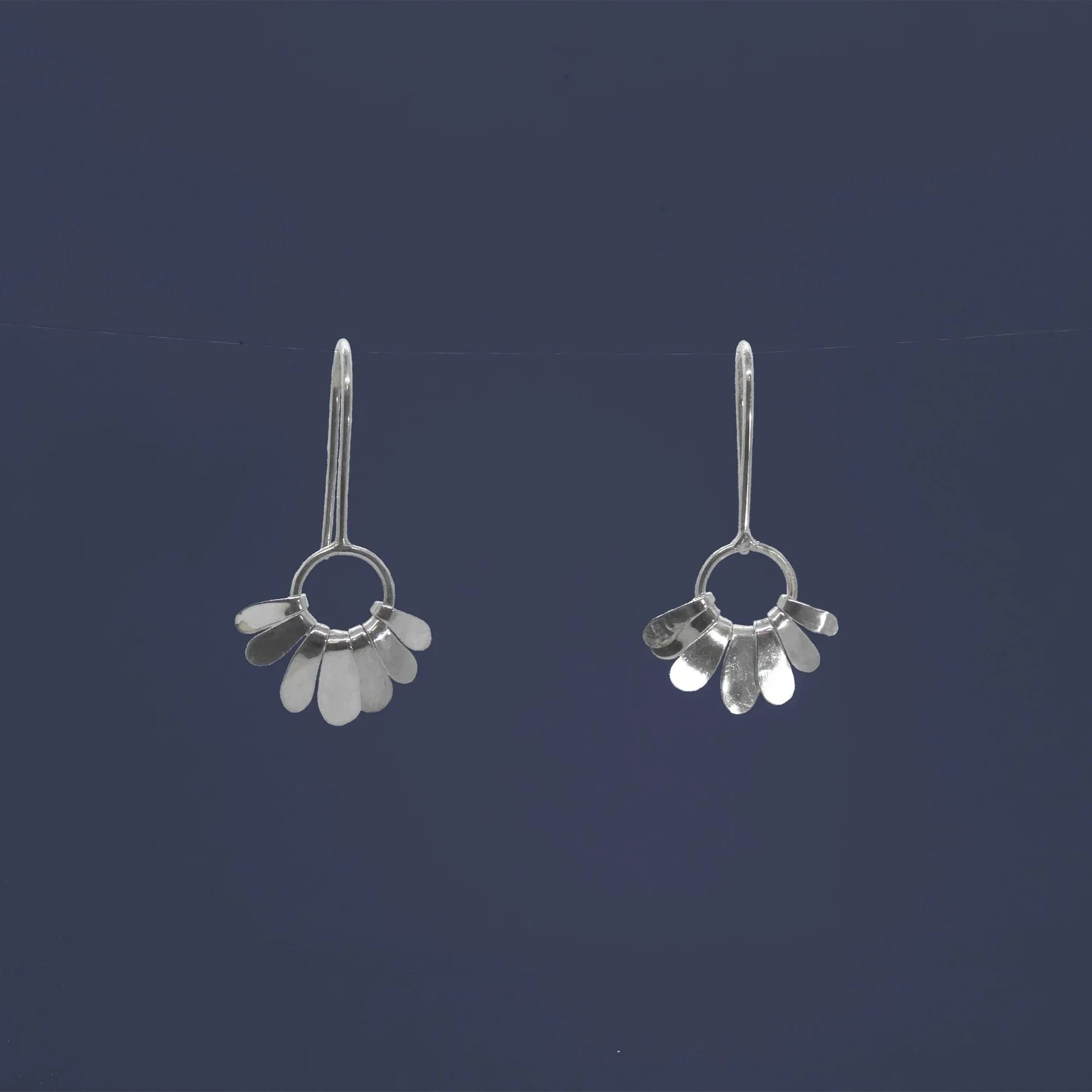 Paquerette: Silver daisy-inspired earrings with dangling petals, handmade in Switzerland contemporary jewelry