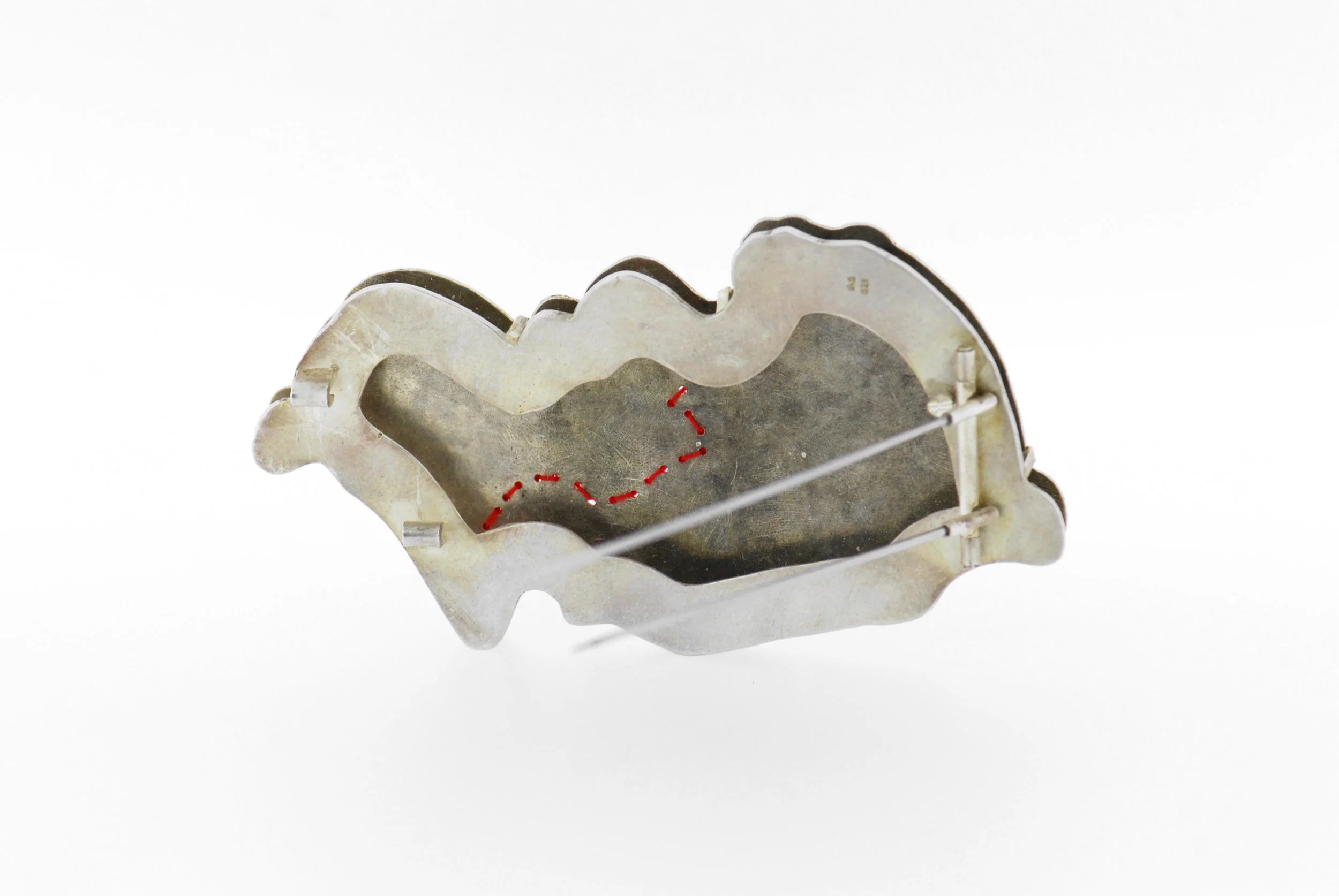 Lace brooch, silver niello and red lace