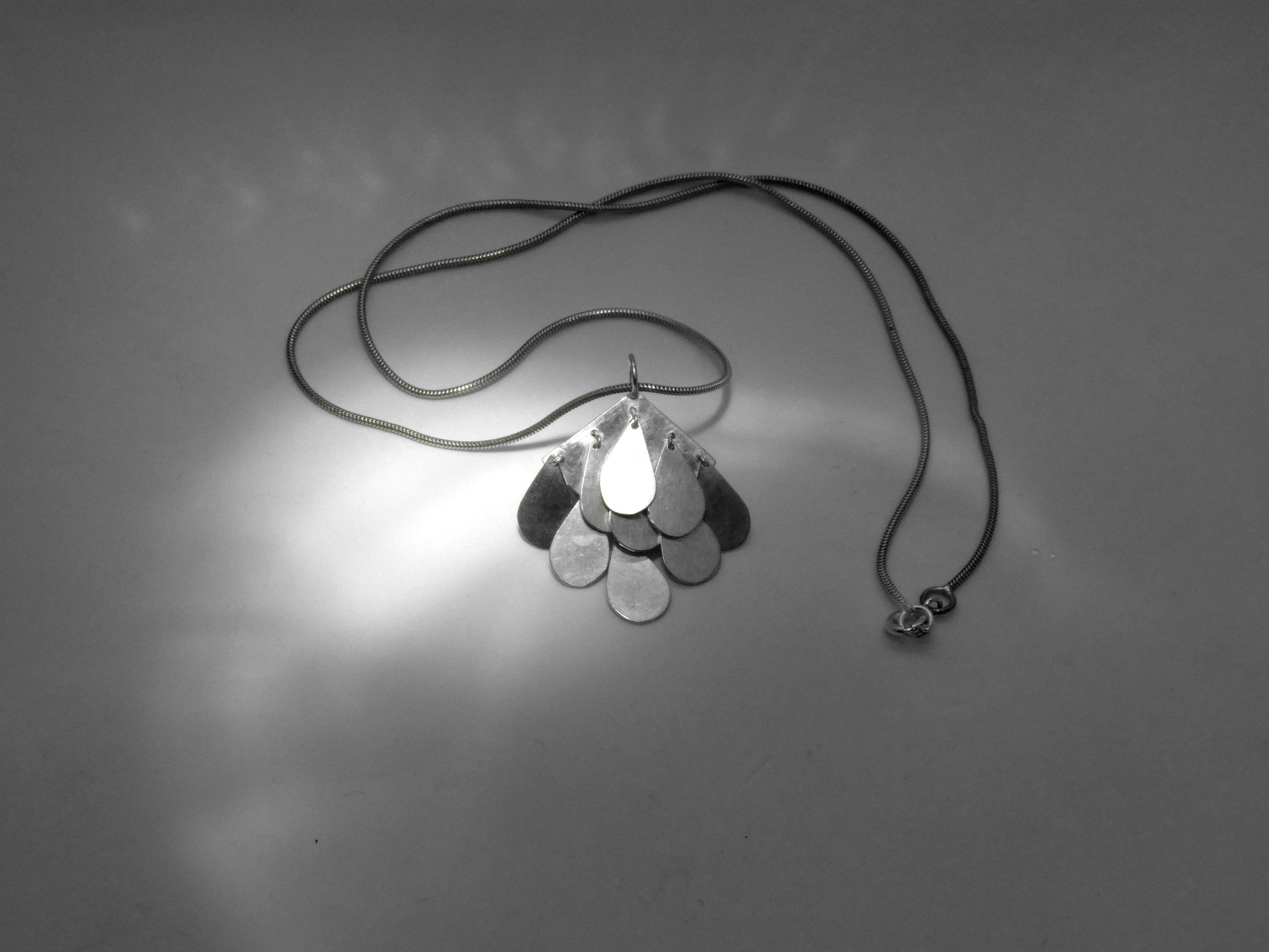 Contemporary silver pendant with moving drops, handmade jewelry Switzerland reflecting light and motion