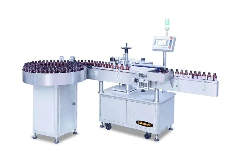 Automatic labeling machine in a pharmaceutical manufacturing setting, handling small bottles.