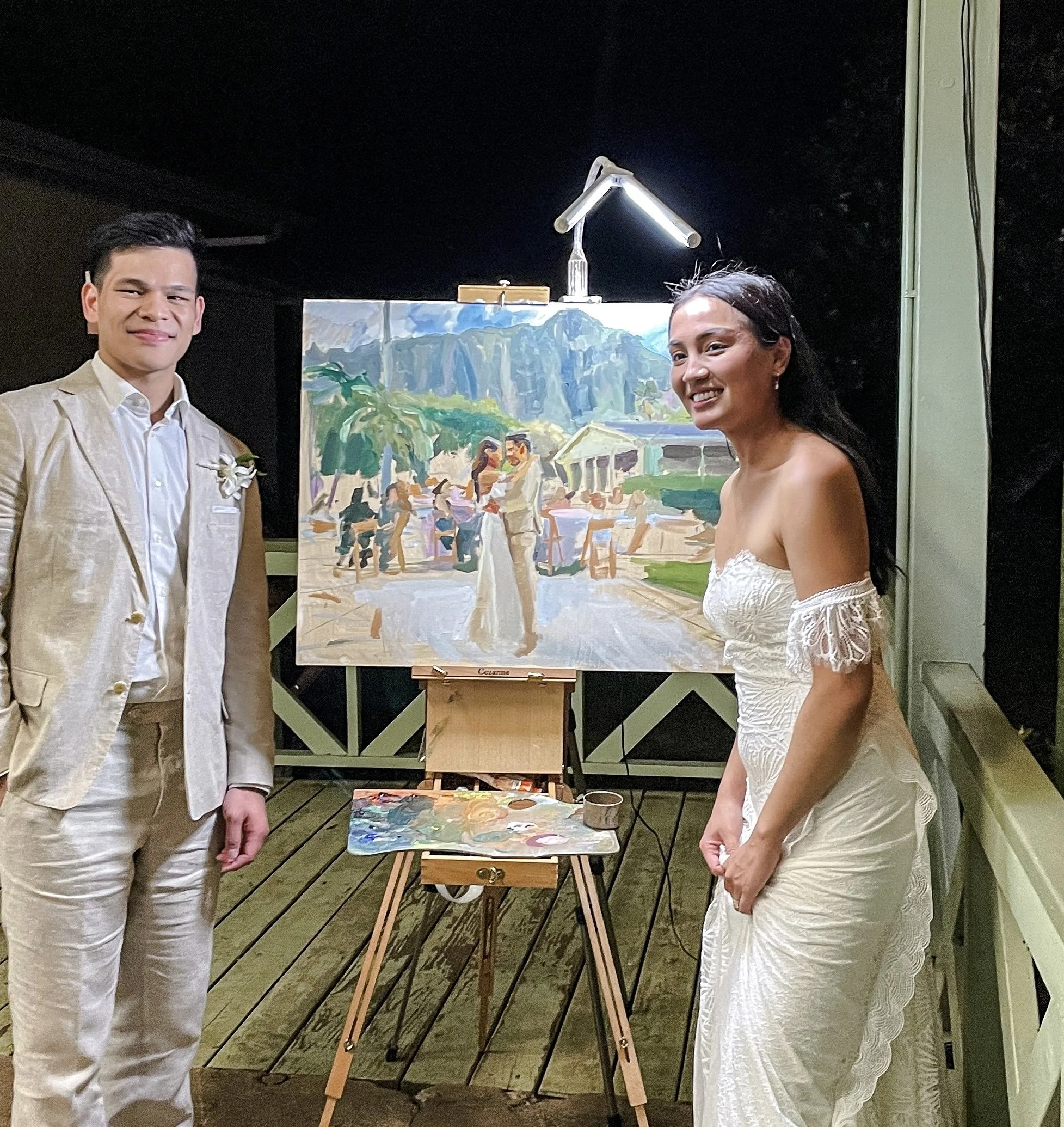 Bride and groom with their finished live wedding painting at Kualoa Ranch, Oahu, by Laura Jane Fine Art