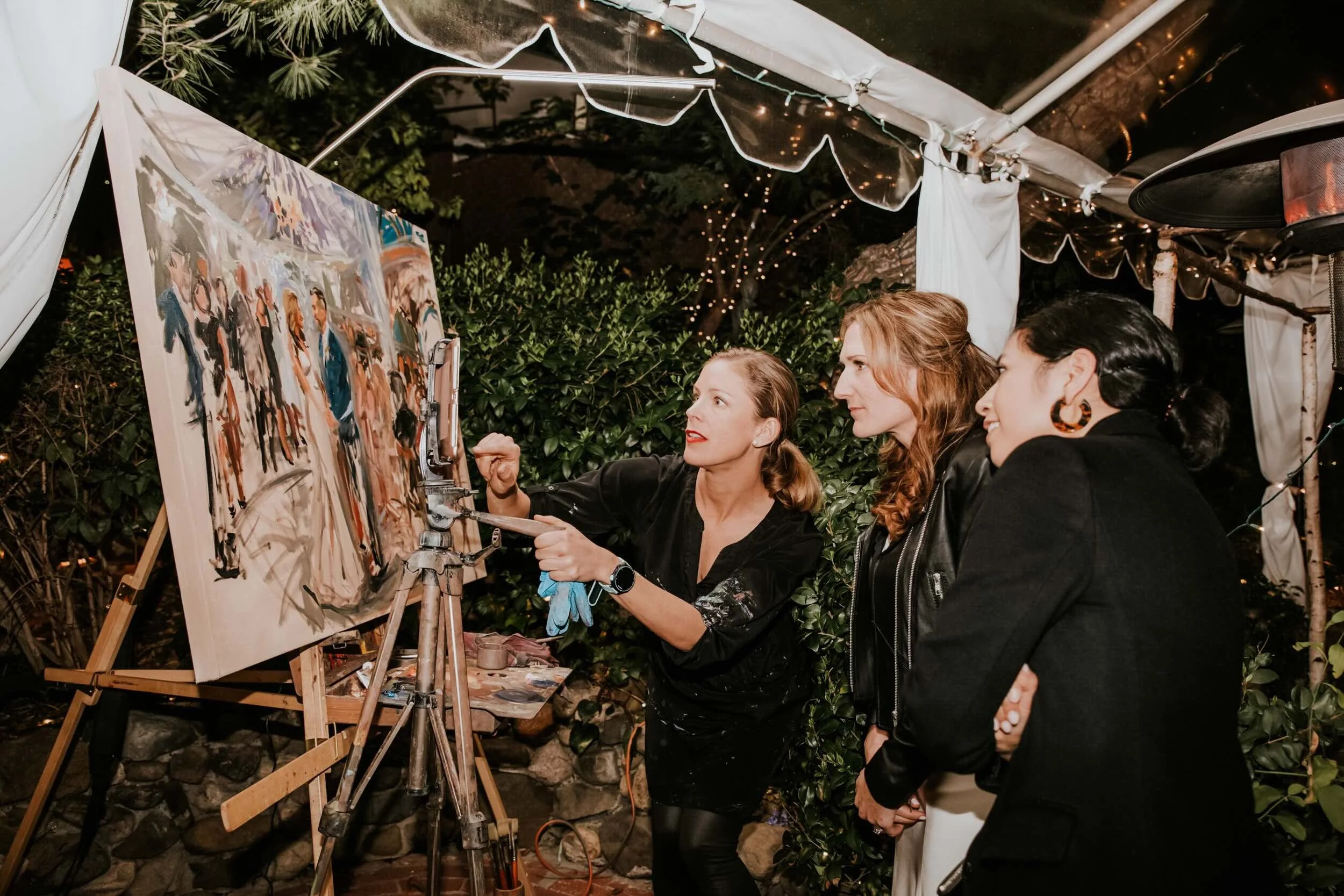 Bride and guests checking out a large live wedding painting in progress