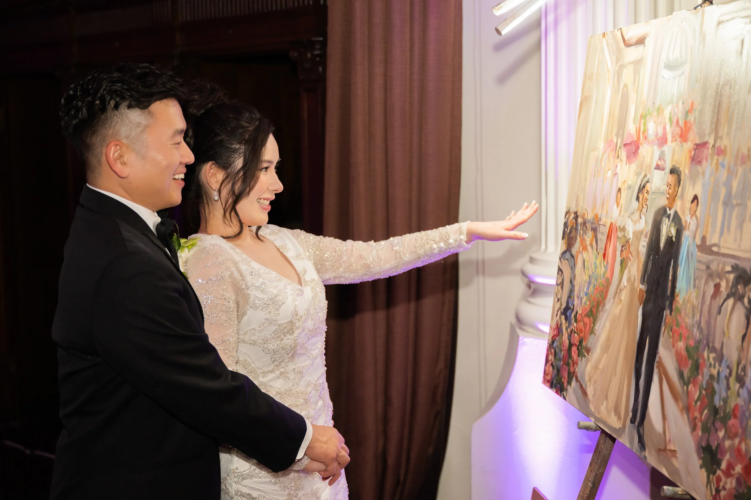 A couple admiring their live wedding painting in progress at the Vibiana in Los Angeles