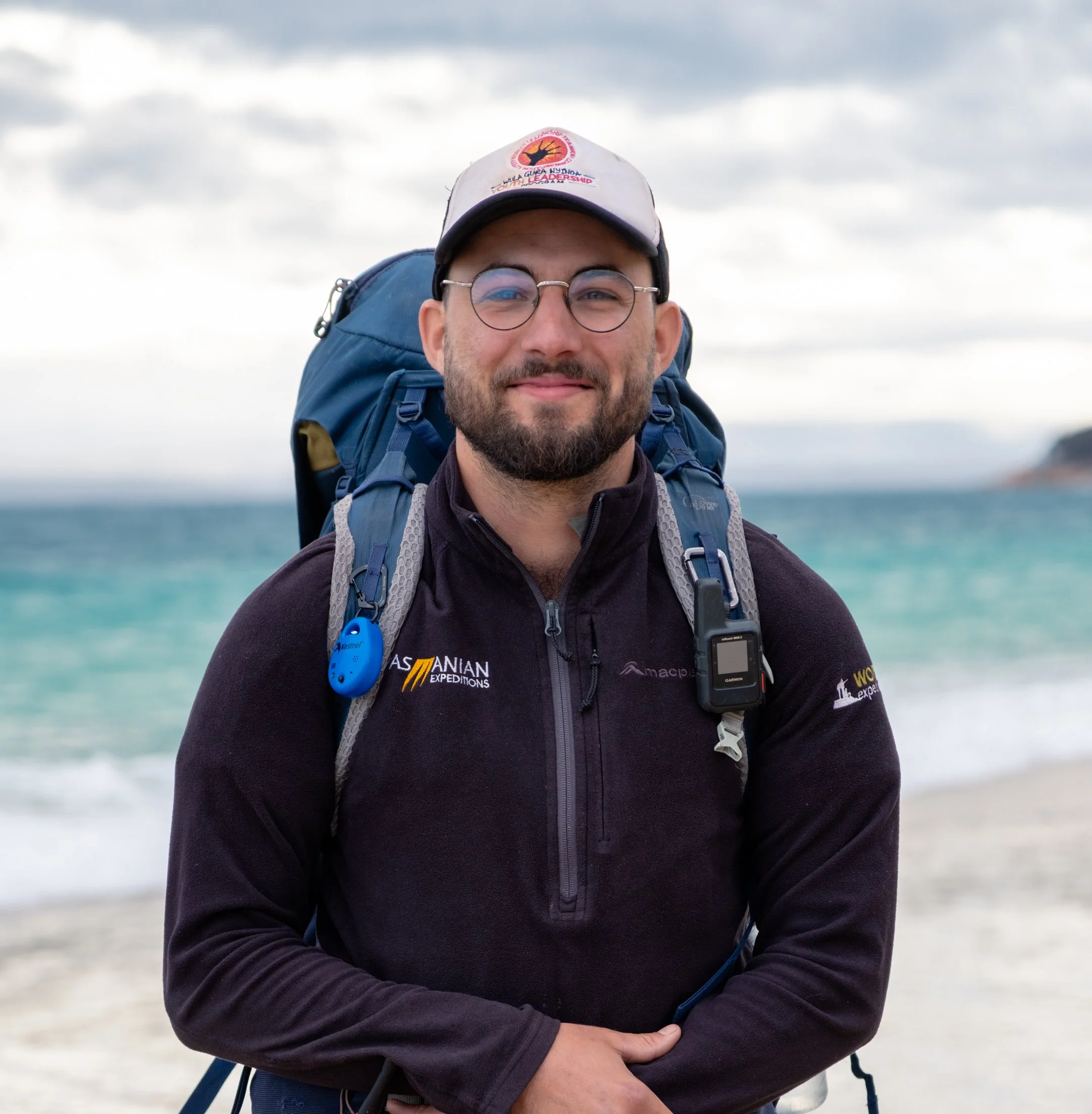 guide stood on beach with ocean behid