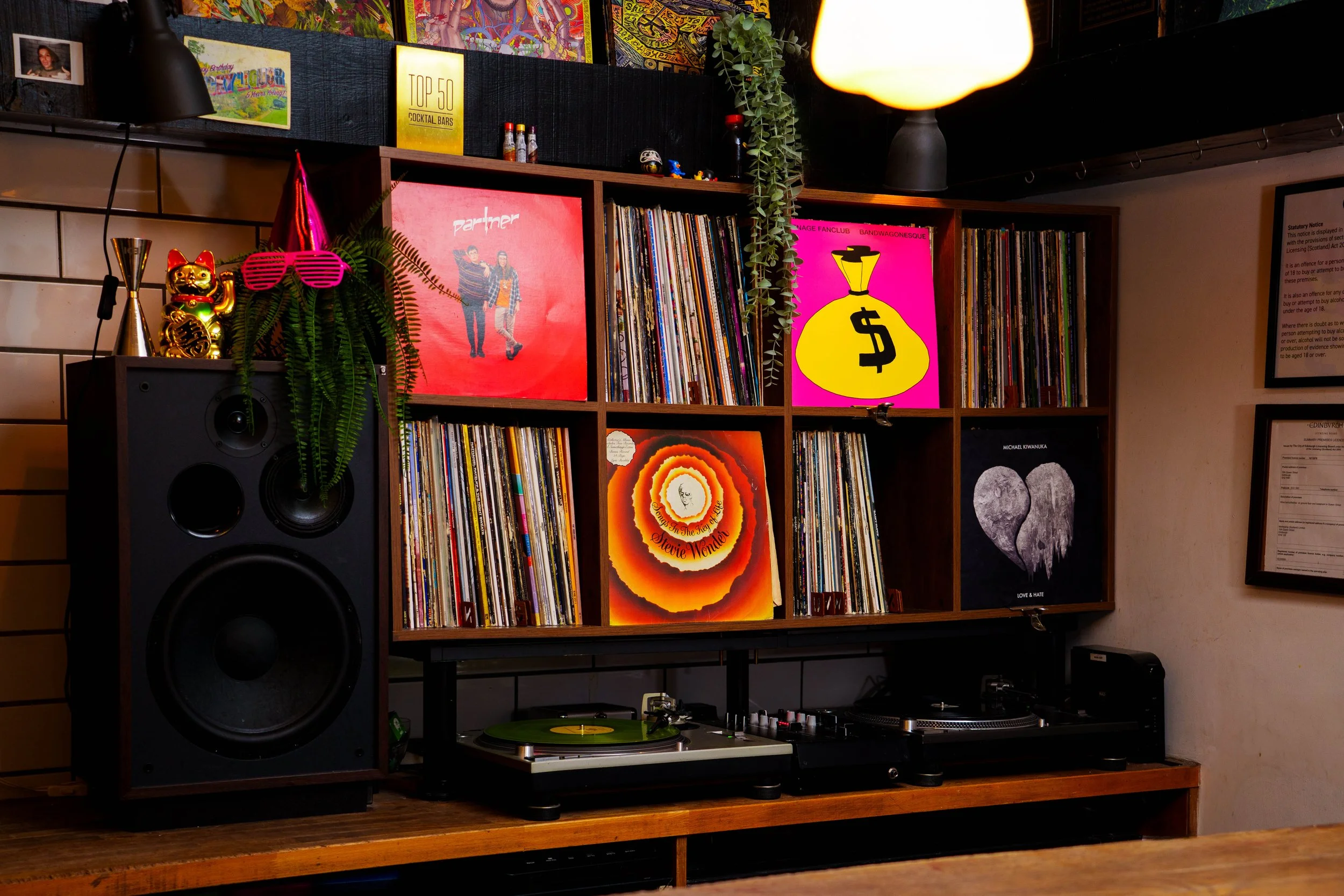 Vinyl records and turntables in a warm-lit bar, representing curated music direction.