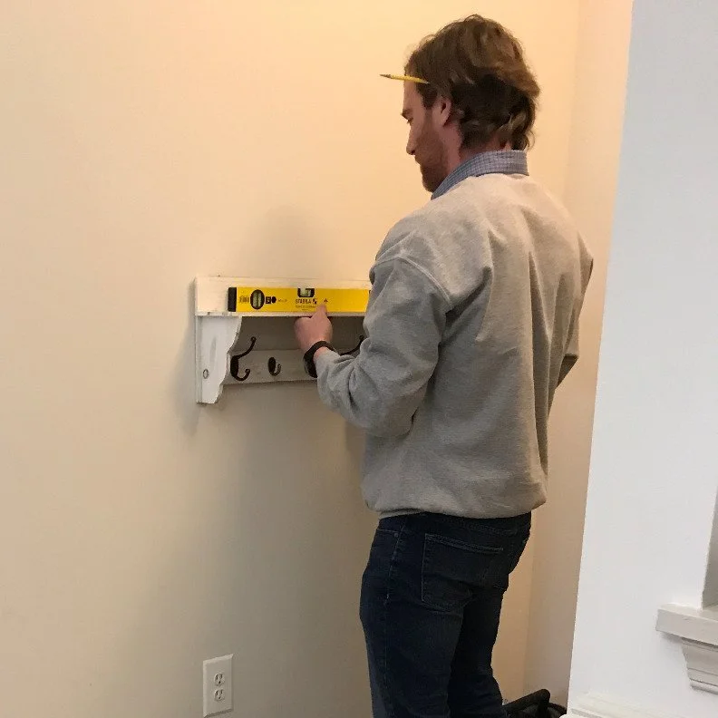 Person installing items on wall during home setup and staging.