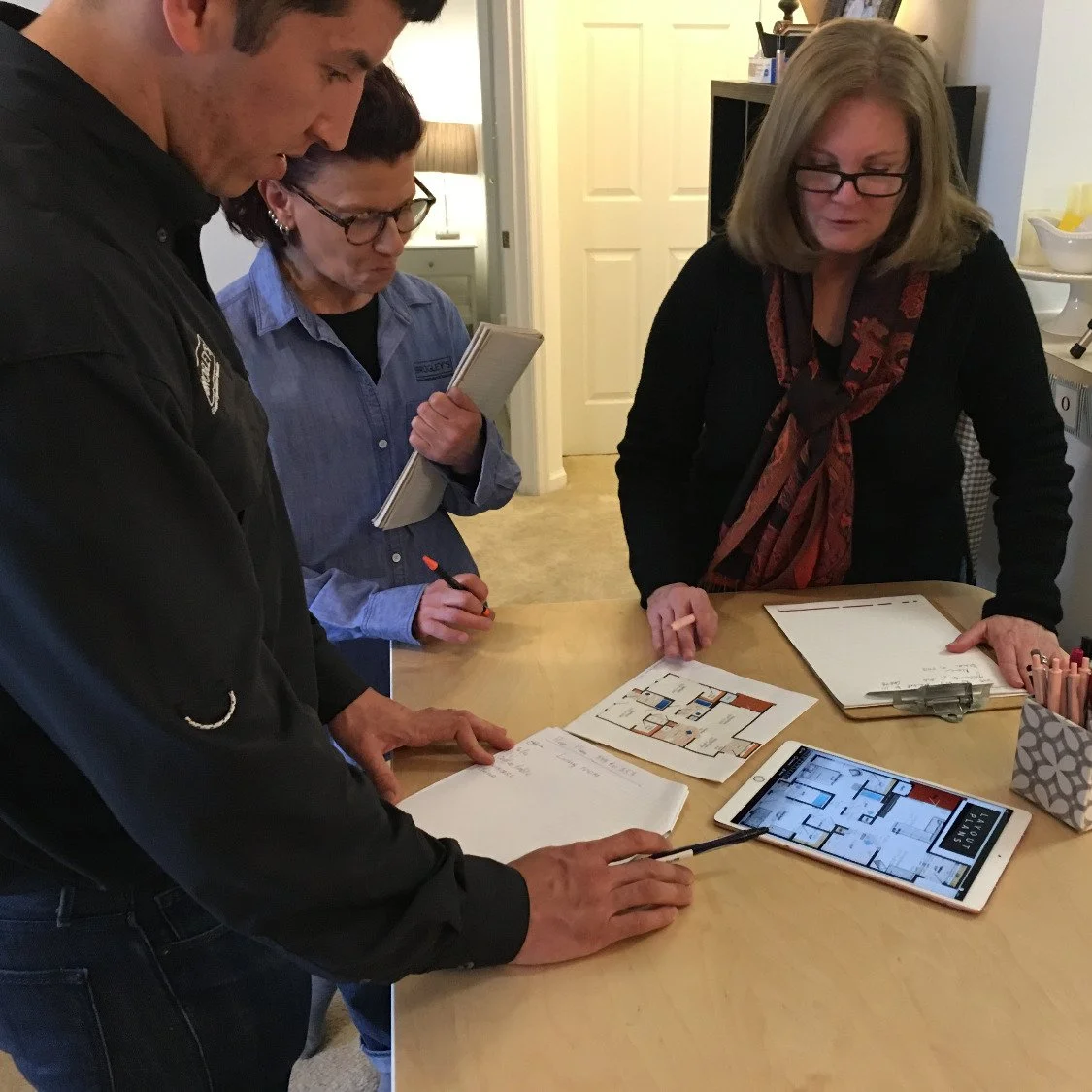 Team reviewing floor plans and notes during move management consultation.