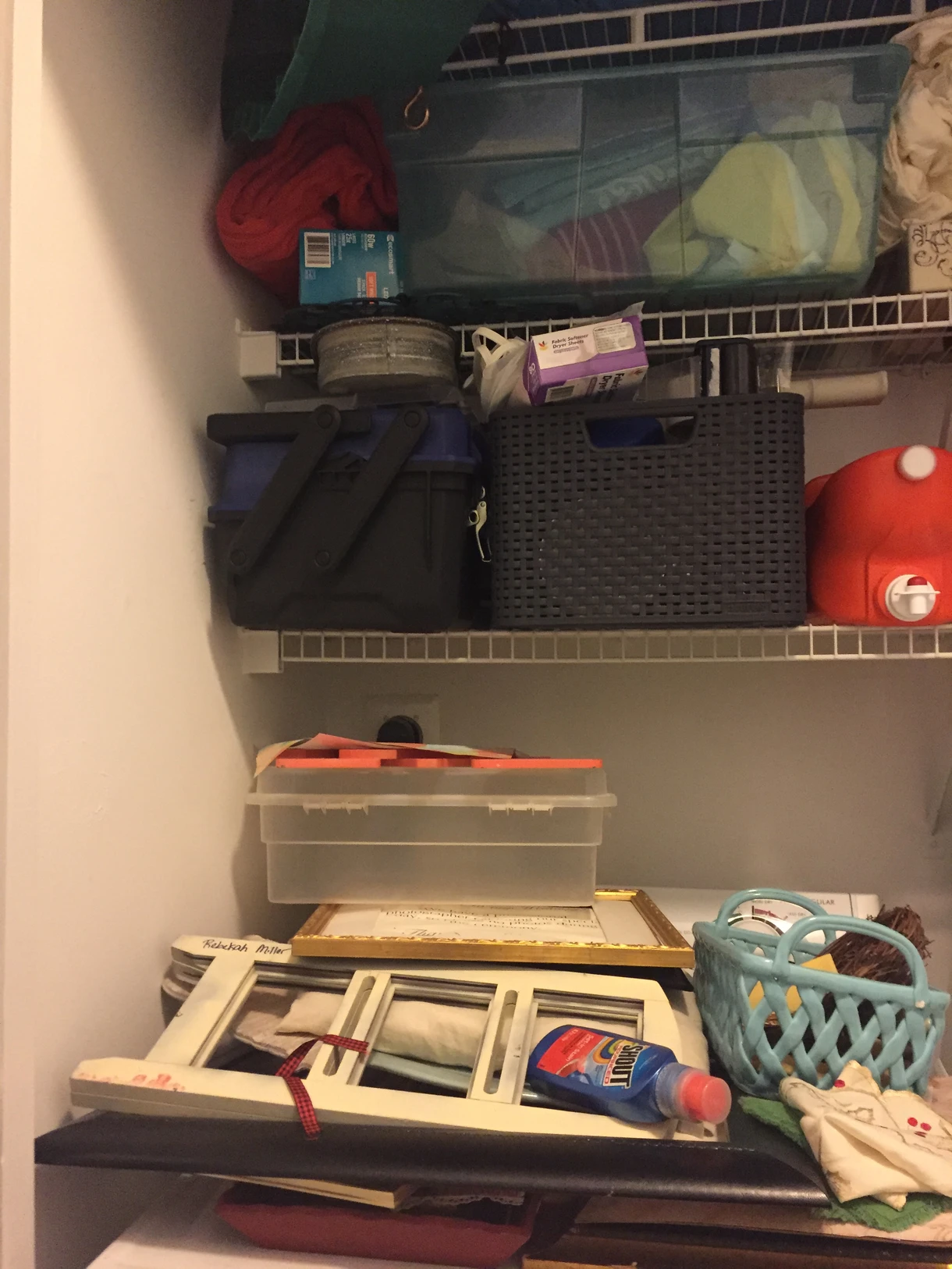Bathroom cabinet with disorganized toiletries and household items before decluttering.