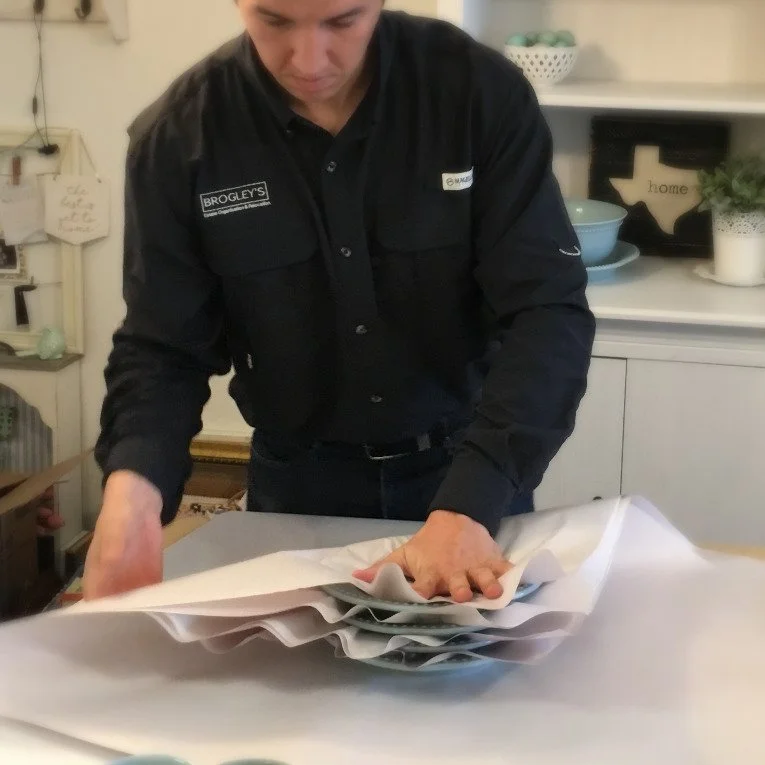 Professional carefully packing items with protective wrapping for a move.