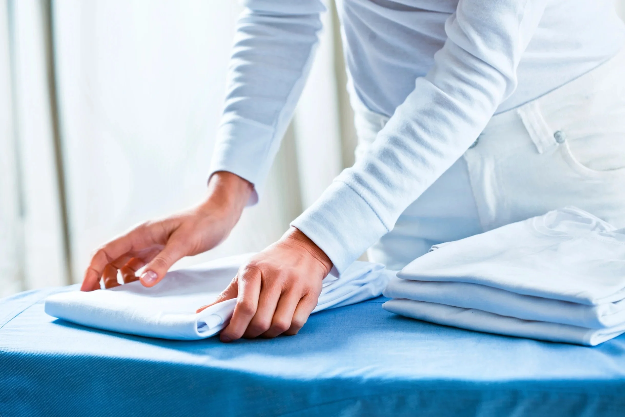 Hand smoothing a textured fabric surface during cleaning or organizing.