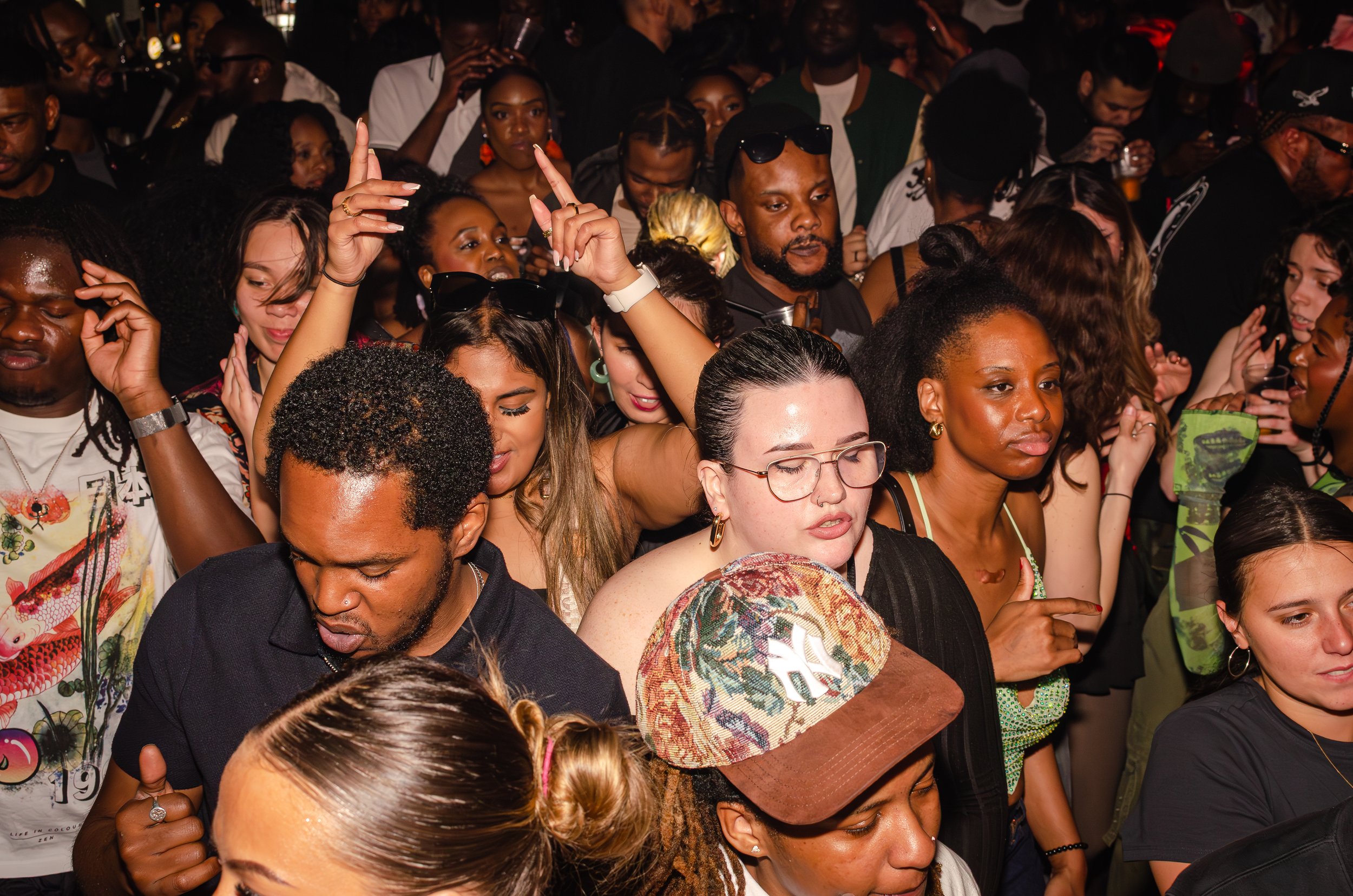 A crowded nightclub with diverse people dancing and enjoying the music.