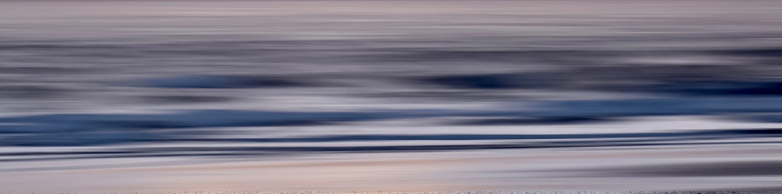 Blurred motion of ocean waves with a color gradient from light to dark