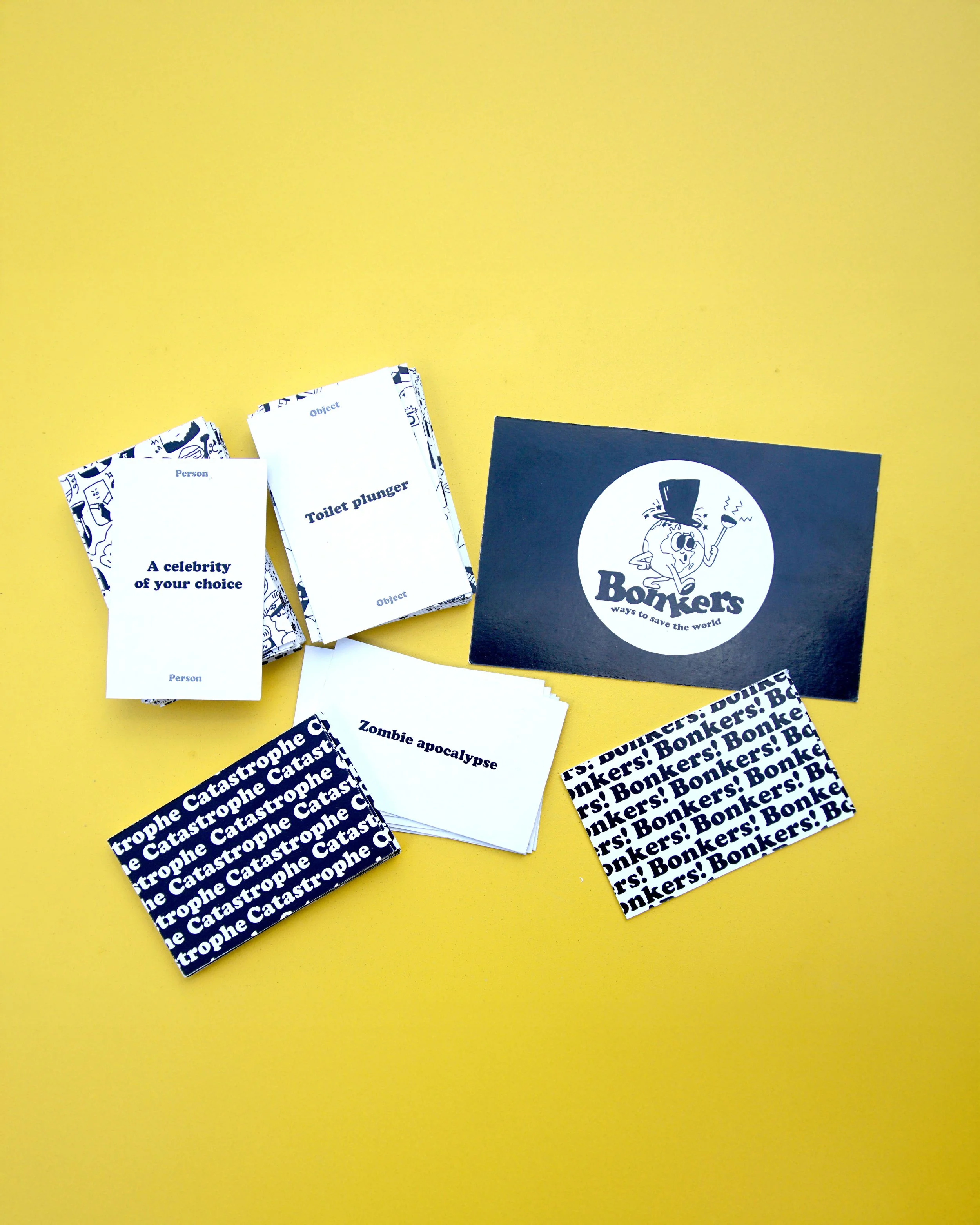 A yellow background with several white cards containing text, some cards with patterned borders, and a black card with a cartoon figure and the text "Bonkers." The white cards have phrases like "A celebrity of your choice," "Toilet plunger," "Zombie apocalypse," and others.