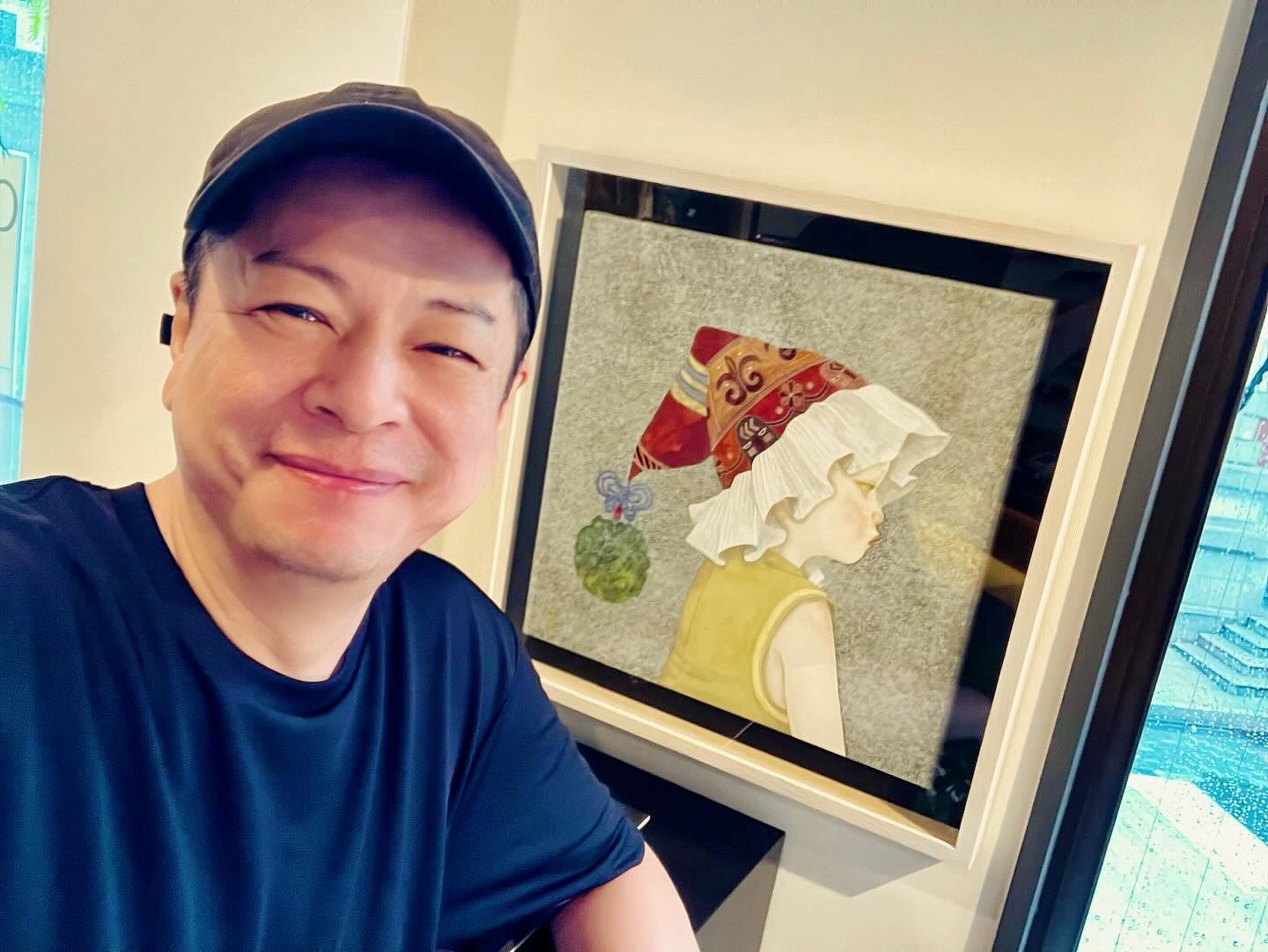 笑顔の男性がアートの前で写真を撮っている。