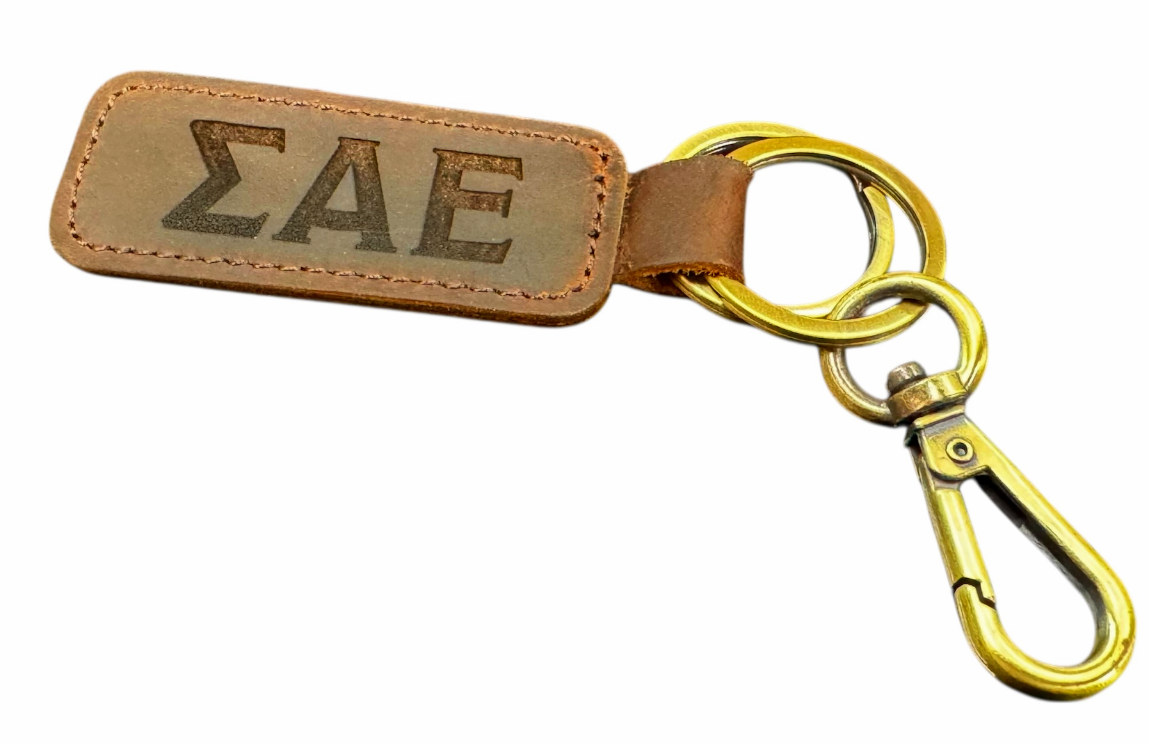 Leather keychain with Greek letters Sigma Epsilon Alpha engraved on a rectangular tag attached to a metal keyring and clip.