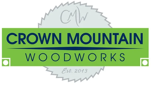 Logo for Crown Mountain Woodworks with green and blue text, a gray circular emblem, and established in 2013
