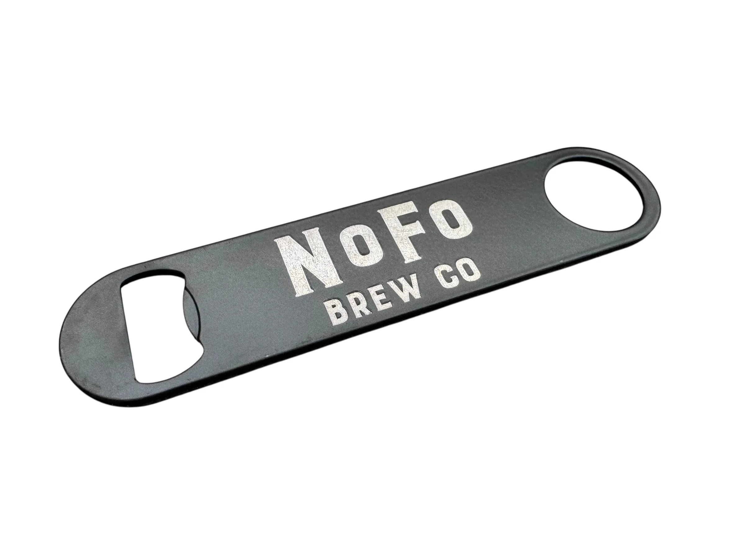 A gray bottle opener with the words 'NOFO BREW CO' printed on it, featuring a circular opening on one end and a rectangular opening on the other.
